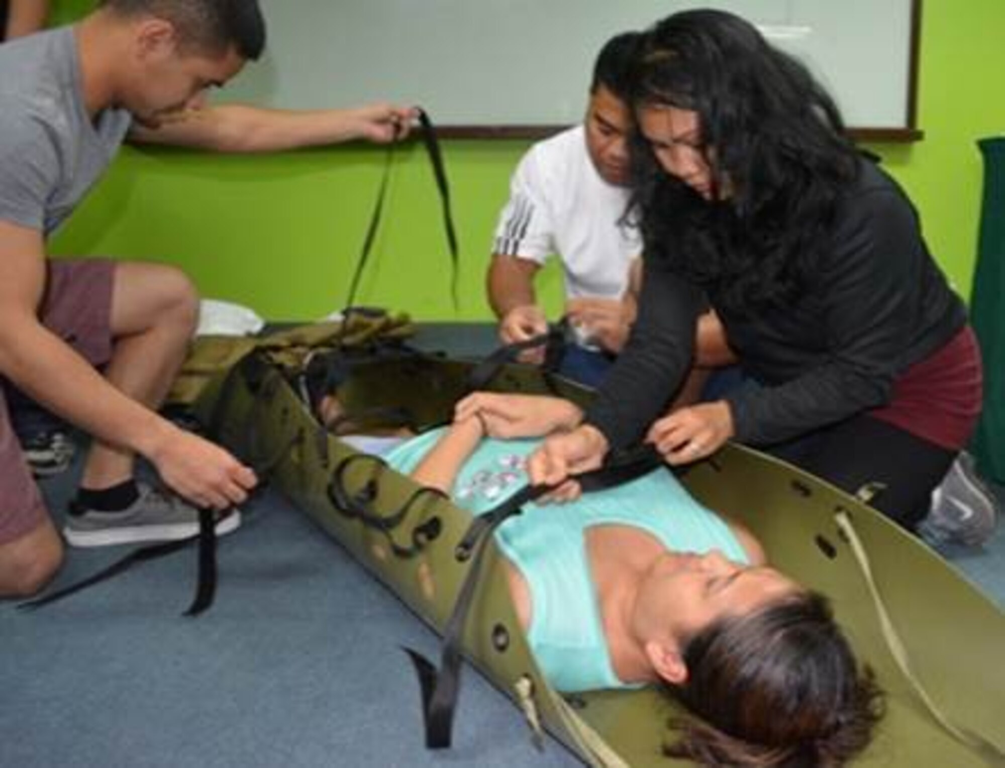 Capt. Janet Baxa, right, a nurse with the 624th Aeromedical Staging Squadron, Joint Base Pearl Harbor-Hickam, Hawaii, secures a rapid extraction litter during a training course, Cavite, Philippines, Mar. 22, 2014. (Courtesy photo/Guam Army National Guard)