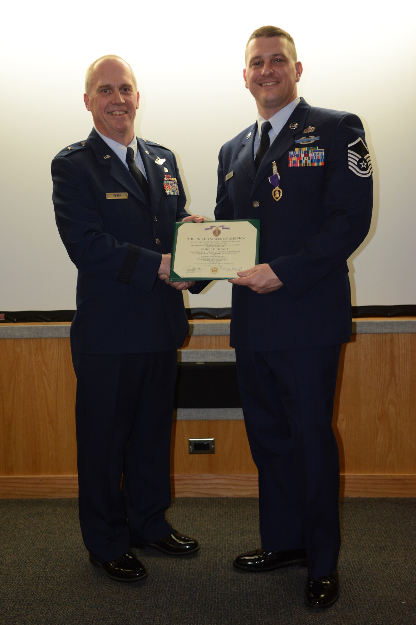 Brig. Gen. Gary L. Ebben, Wisconsin's assistant adjutant general for Air, and Master Sgt. Joshua Johnson, 115th Fighter Wing budget analyst, pose following Johnson’s Purple Heart ceremony at the 115 FW in Madison, Wis., May 3, 2014. Johnson was awarded the medal after being thrown from his gunner’s seat and injured during a 2005 deployment. (Air National Guard photo by Senior Airman Andrea F. Liechti)