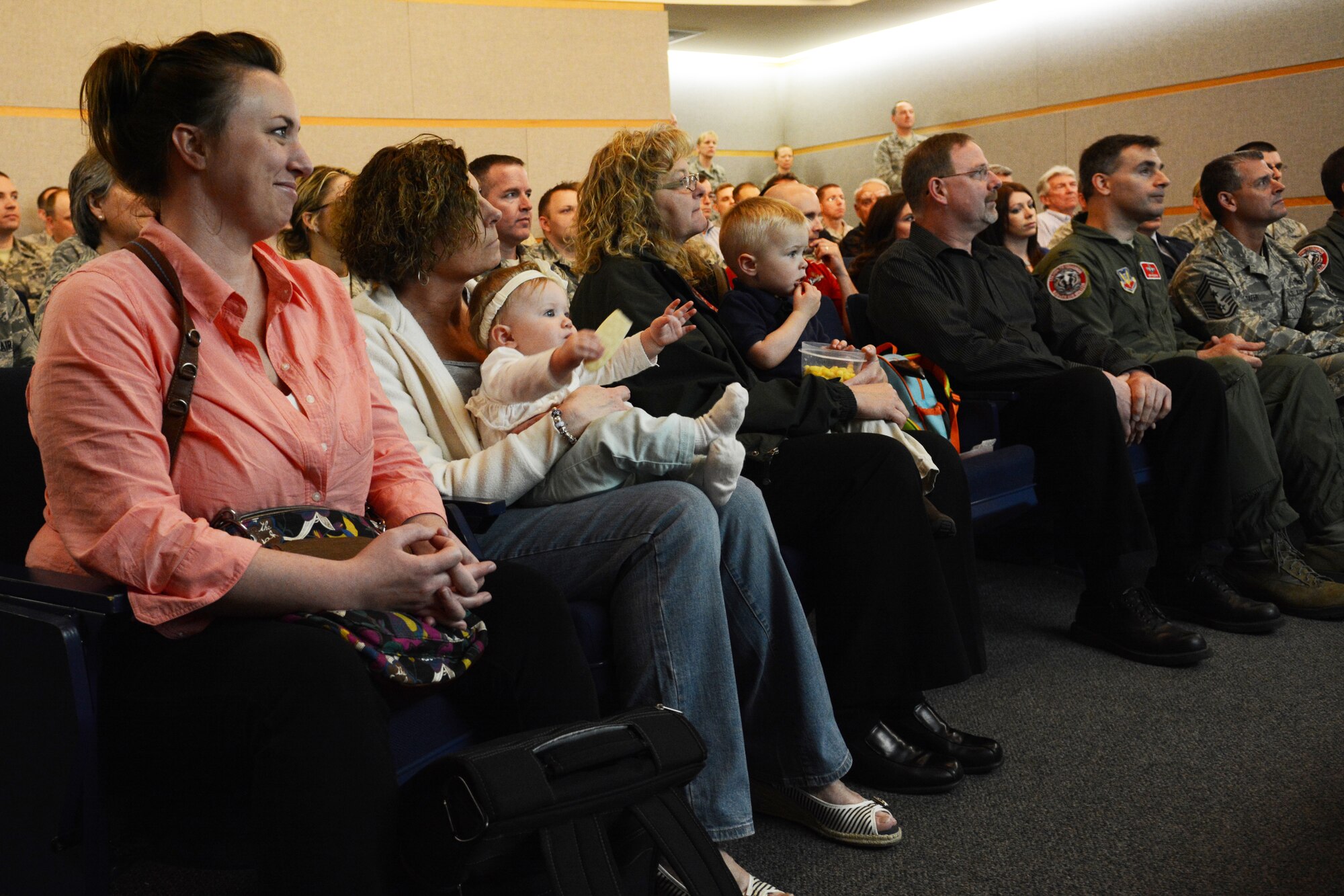 A room full of people watch Master Sgt. Joshua Johnson, 115th Fighter Wing budget analyst, receive a Purple Heart medal during a ceremony at the 115 FW in Madison, Wis., May 3, 2014. Johnson was awarded the medal after being thrown from his gunner’s seat and injured during a 2005 deployment. (Air National Guard photo by Senior Airman Andrea F. Liechti)
