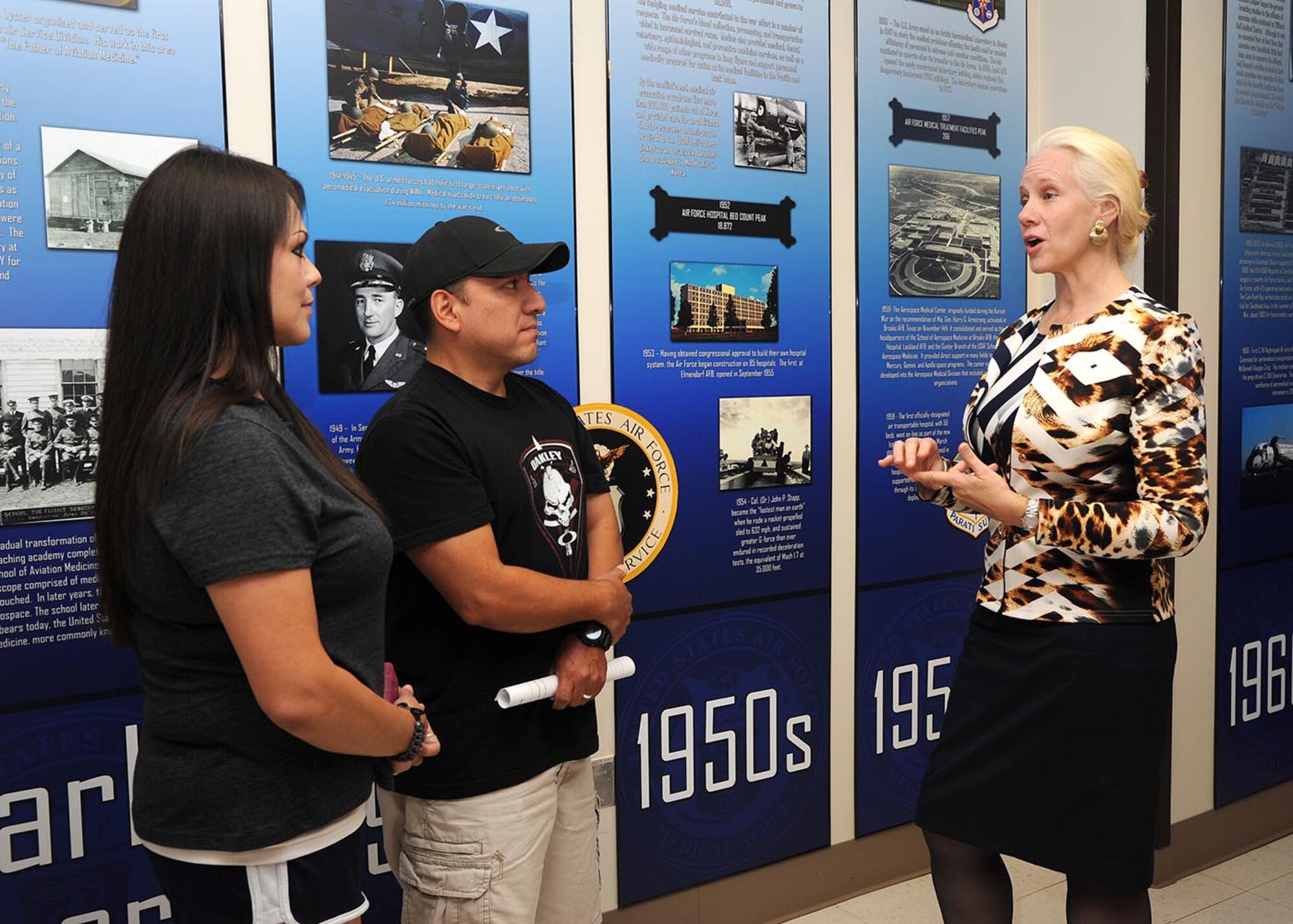 Judith Taylor, Air Force Medical Service historian, talks with retired Air Force Master Sgt. Tony Garcia and his wife, Gracie, about the medical history display May 21, 2014 at the Wilford Hall Ambulatory Surgical Center, Joint Base San Antonio-Lackland, Texas.  This display was built so that patients and visitors to the WHASC could learn about the AFMS history and its contributions to the Air Force and military medicine. (U.S. Air Force photo/Harold China)