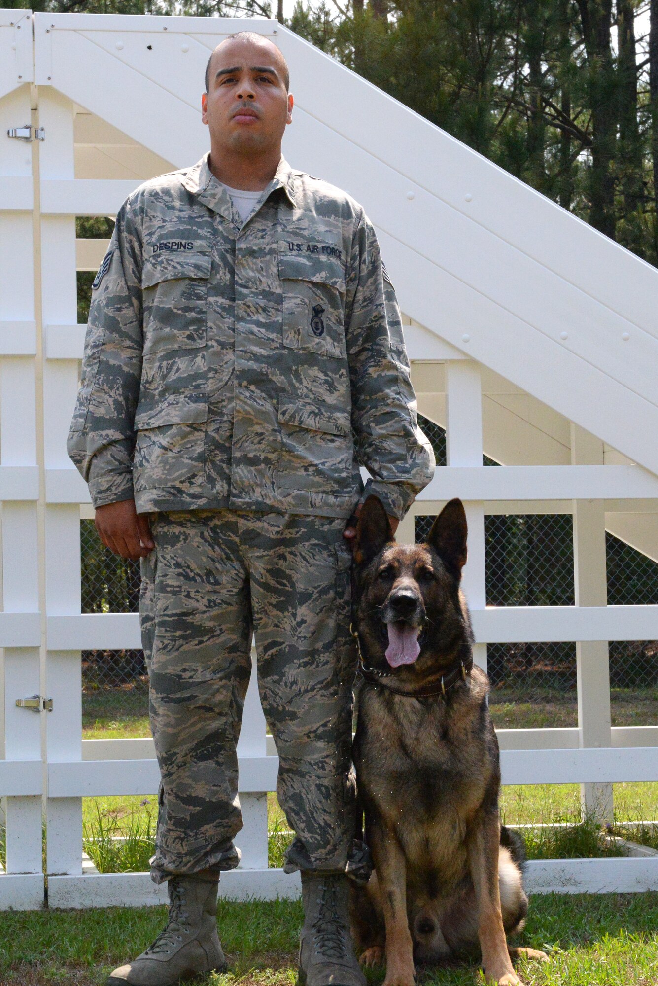 U.S. Air Force Staff Sgt. Anthony Despins, 20th Security Forces Squadron military working dog handler, orders Jasko V095, 20th SFS MWD, to sit and stay, Shaw Air Force Base, S.C., May 27, 2014. While outdoors with a pet, be sure to monitor the temperature as well as time spent outside. Make sure to provide plenty of water or ice cubes to keep them from getting dehydrated or suffering from heat stroke. (U.S. Air Force photo by Airman 1st Class Diana M. Cossaboom/Released)