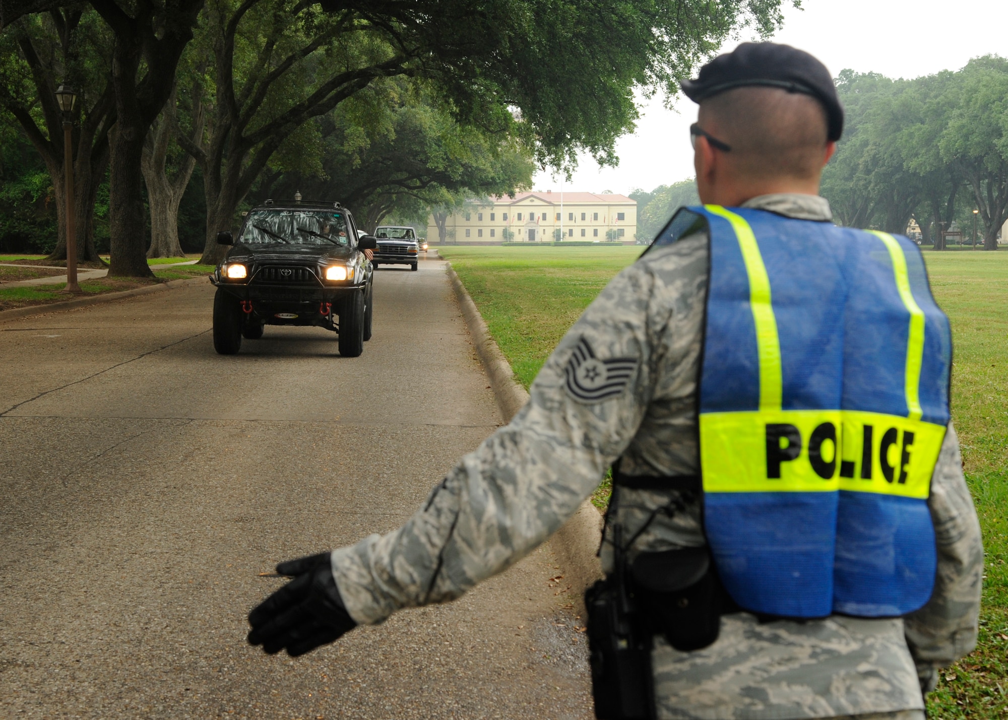 Tech. Sgt. Jeffrey Lucas, 2nd Security Forces Squadron assistant flight chief, signals for oncoming traffic to stop for a random seat belt inspection on Barksdale Air Force Base, La., May 27, 2014. Security Forces and civilian law enforcement agencies are performing additional seat belt checks from May 19th - June 1st for the Click It or Ticket campaign. (U.S. Air Force photo/Senior Airman Joseph A. Pagán Jr.)