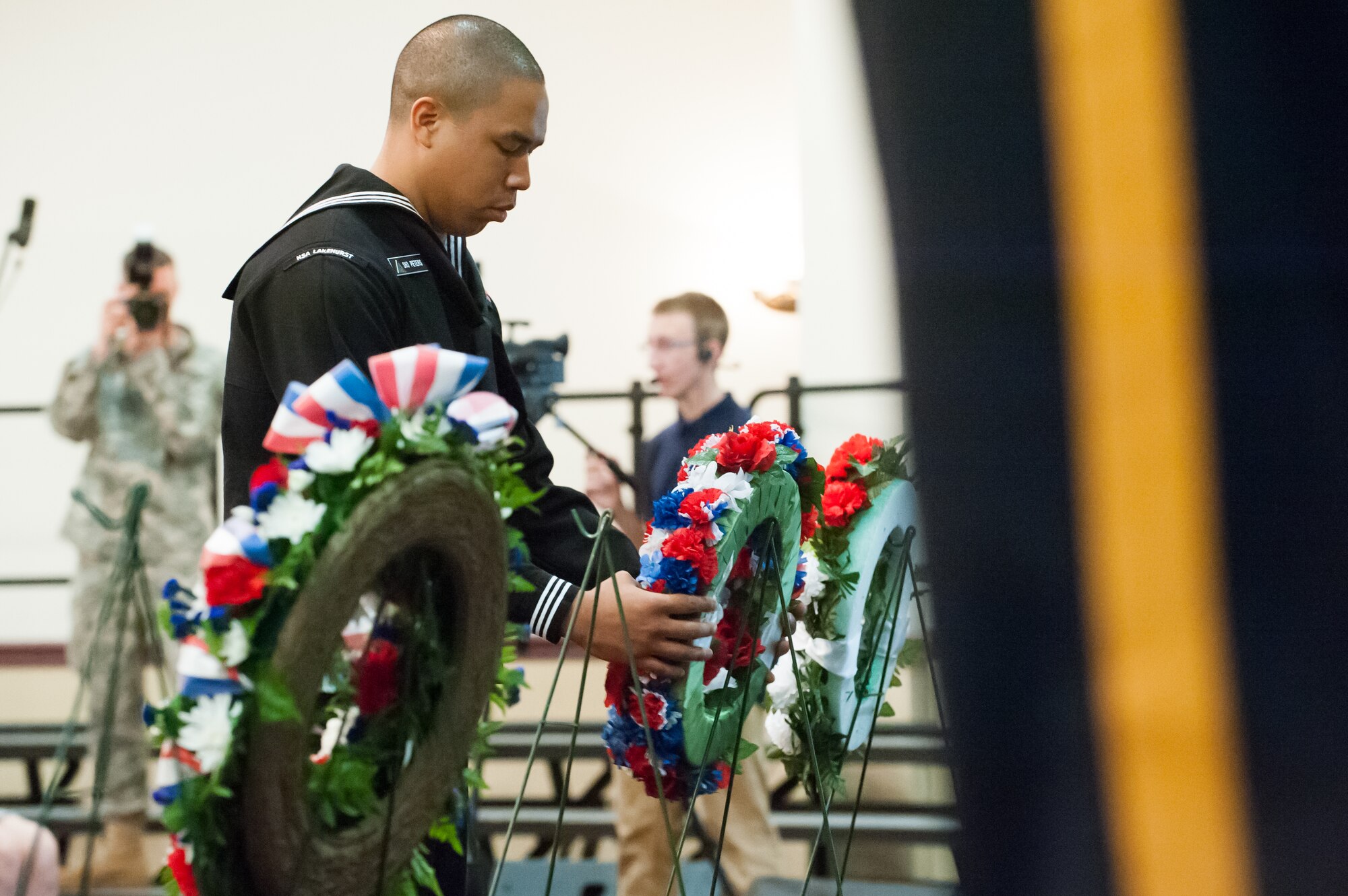 A Navy Support Activity Lakehurst Sailor places a wreath on a display during the annual Parade of Wreathes ceremony May 22, 2014, at Tommy B’s Community Activities Center, Joint Base McGuire-Dix-Lakehurst, N.J. The event honored service member and police personnel who have given their lives in the line of duty. (U.S. Air Force photo by Russ Meseroll/Released) 