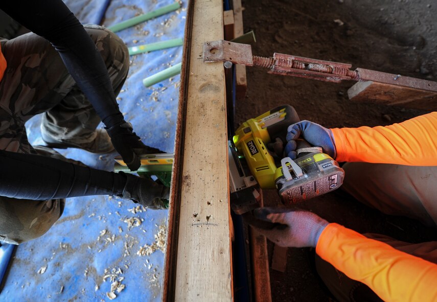 (from left to right) Dan Folta, a native of Wisconsin assists Kevin Hummer, also a Wisconsin native and concrete worker, with setting dowels in the floor of the new double phase dock at Minot Air Force Base, N.D., May 16, 2014. The process of placing the dowels consists of constant checks to ensure that they are level as well as team work to hold them in the proper place during installation. (U.S. Air Force photo/Senior Airman Stephanie Sauberan)