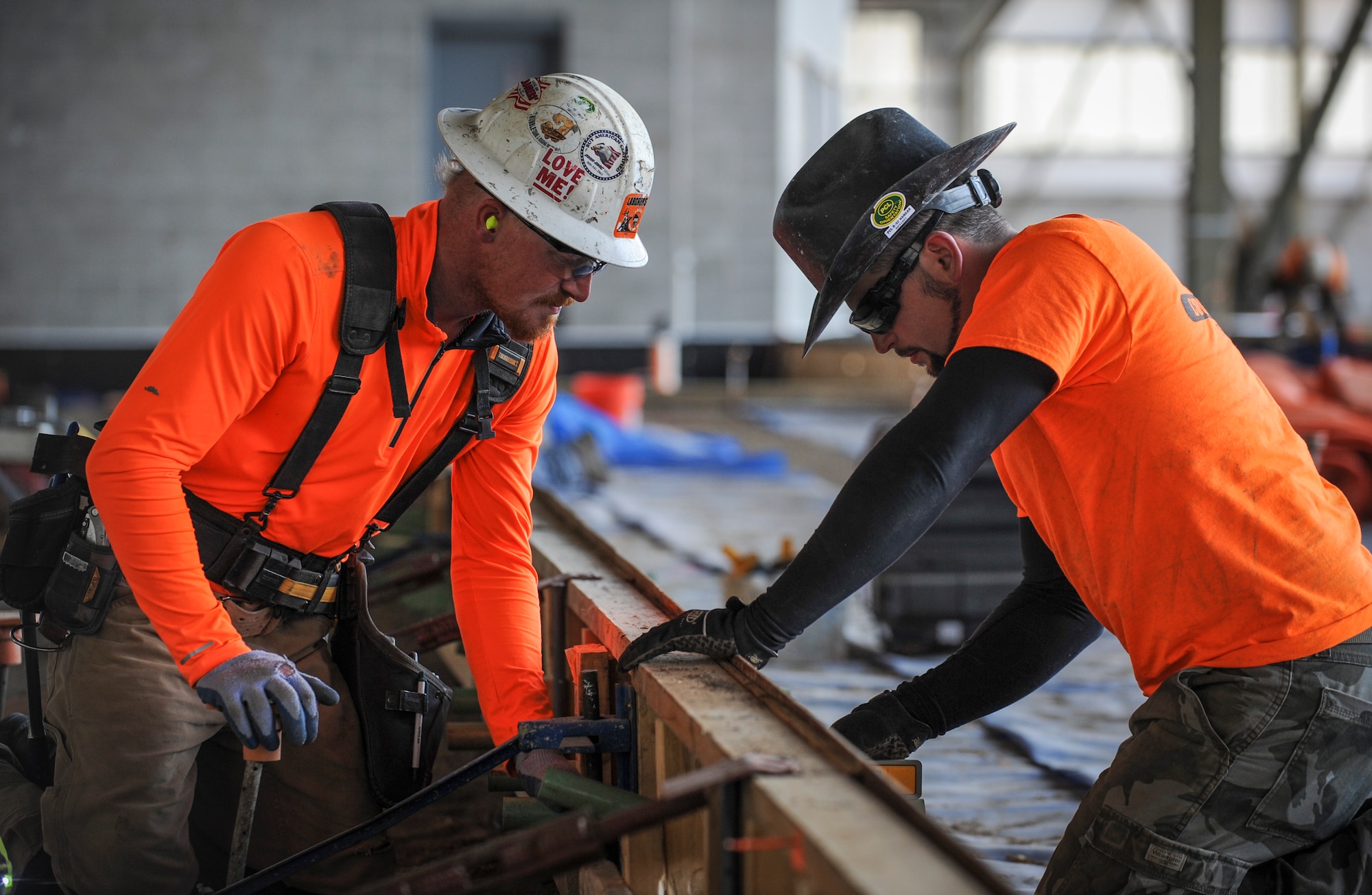 (from left to right) Kevin Hummer, a Wisconsin native and concrete worker assists Dan Folta, also a native of Wisconsin, with setting dowels in the floor of the new double phase dock at Minot Air Force Base, N.D., May 16, 2014. The dowels will create joints that will strengthen the floor and keep cracks from forming if the concrete shifts up or down. (U.S. Air Force photo/Senior Airman Stephanie Sauberan)