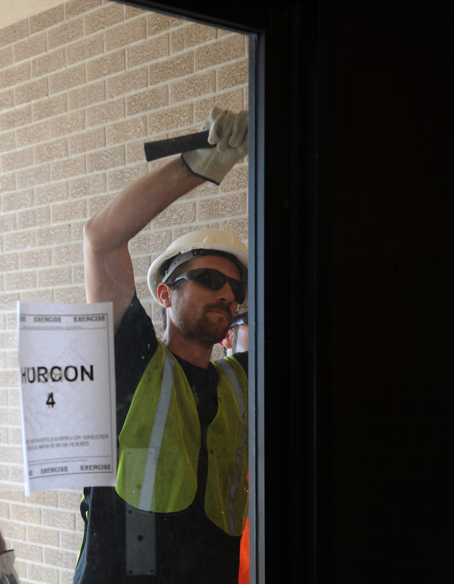 Thomas Frisbie, Pacific Architects and Engineers, secures a set of doors with a board on building 222 during a hurricane exercise May 21, 2014, at Keesler Air Force Base, Miss. Throughout the exercise, “Hurricane Danielle” brought severe thunderstorms, tornado strength winds, rain and hail damage to several base facilities.  The purpose of the exercise was to prepare Keesler for the upcoming hurricane season.  (U.S. Air Force photo by Kemberly Groue)