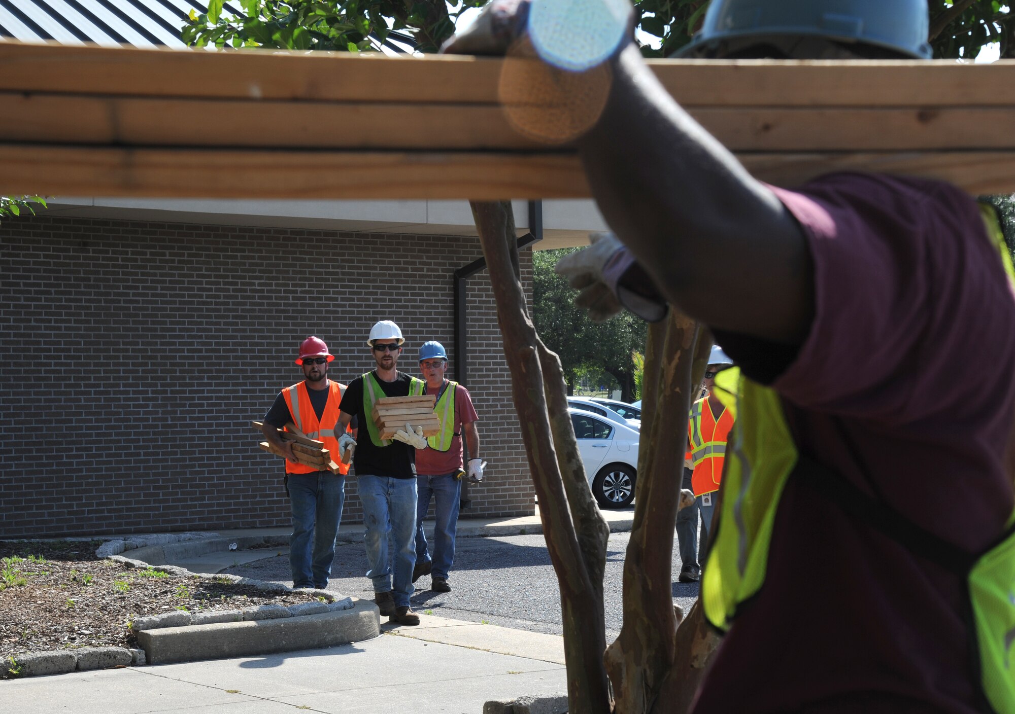 Dennis Fink, Thomas Frisbie and Duane Richards, Pacific Architects and Engineers, secure the doors and windows of building 222, under direction from Kenny King, PAE, during a hurricane exercise May 21, 2014, at Keesler Air Force Base, Miss. Throughout the exercise, “Hurricane Danielle” brought severe thunderstorms, tornado strength winds, rain and hail damage to several base facilities.  The purpose of the exercise was to prepare Keesler for the upcoming hurricane season.  (U.S. Air Force photo by Kemberly Groue)