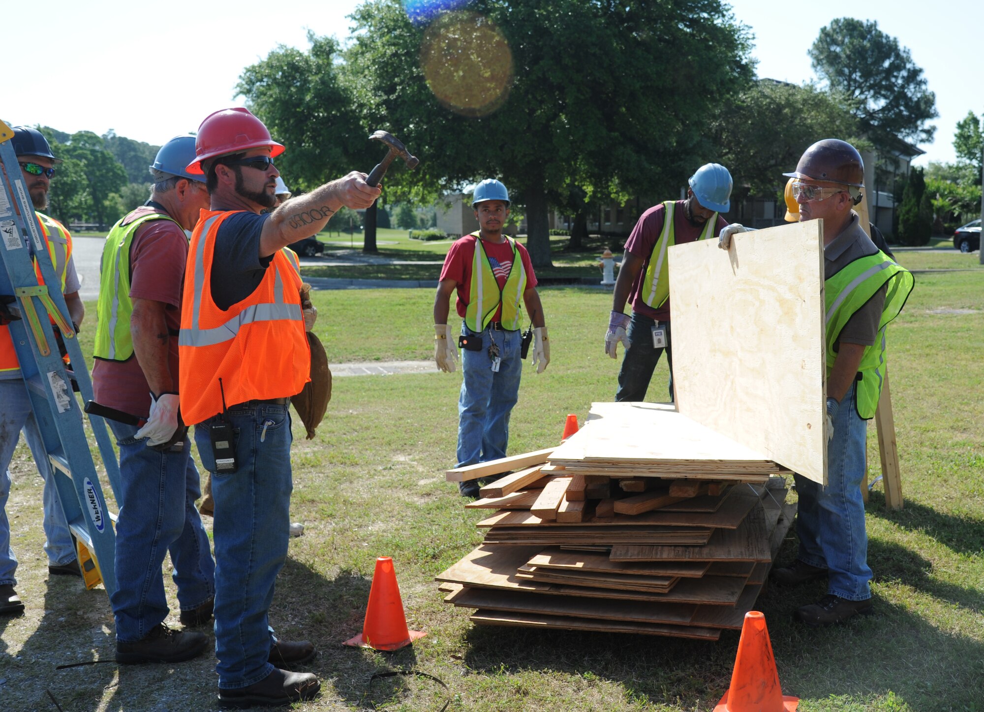 Dennis Fink, Pacific Architects and Engineers, gives direction for placing boards around the building to secure the doors and windows of building 222 during a hurricane exercise May 21, 2014, at Keesler Air Force Base, Miss. Throughout the exercise, “Hurricane Danielle” brought severe thunderstorms, tornado strength winds, rain and hail damage to several base facilities.  The purpose of the exercise was to prepare Keesler for the upcoming hurricane season.  (U.S. Air Force photo by Kemberly Groue)