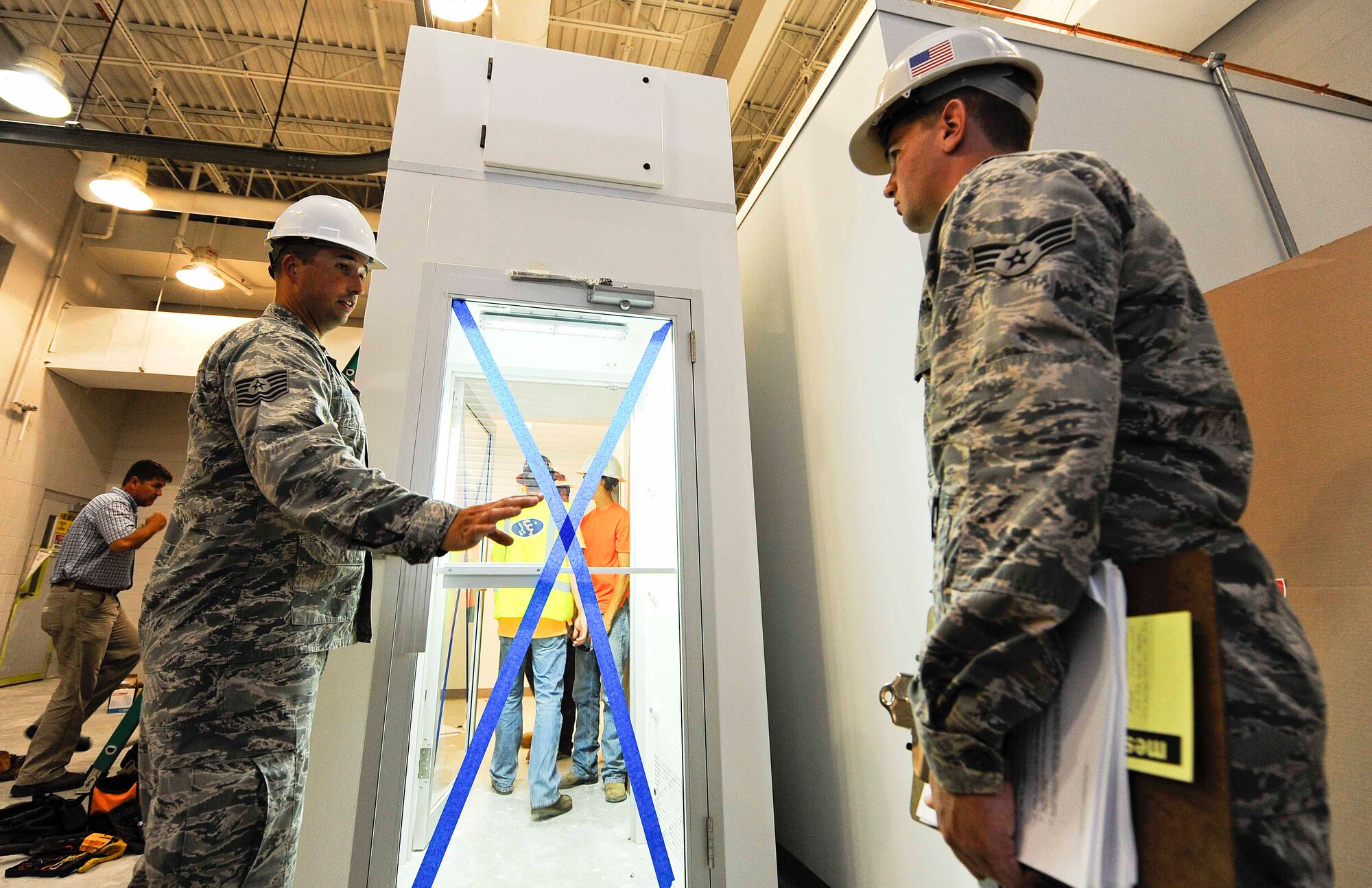 Tech. Sgt. Timothy Emeott, 1st Special Operations Contracting Squadron contracting officer, and Senior Airman William Farr, 1st SOCONS contracting specialist, oversee construction of an air shower at Hurlburt Field, Fla. May 20, 2014. The 1st SOCONS ensures that all available resources are used properly during construction projects. (U.S.  Air Force photo/Airman 1st Class Andrea Posey)