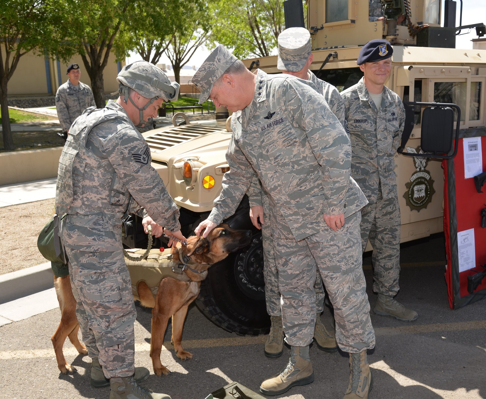 Gen. Mark A. Welsh III, Chief of Staff of the Air Force, greets Airman 1st Class Donovan Vulgamore, 377th Security Forces Squadron, and a military working dog during a May 20 visit to Kirtland. Welsh spent several days at the base touring facilities and meeting with Airmen. (Photo by Ken Moore)
