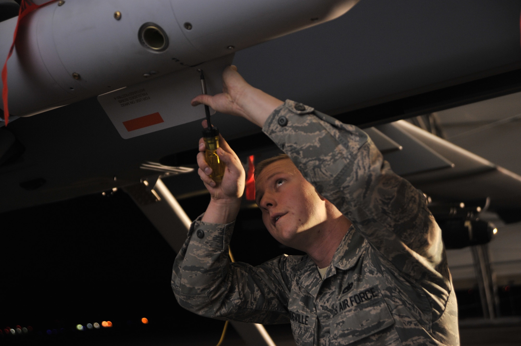 Staff Sgt. Daniel, 432nd Aircraft Maintenance Squadron Tiger Aircraft Maintenance Unit weapons load crew member, fastens a GBU-12 Paveway II laser-guided bomb onto an MQ-9 Reaper during Combat Hammer May 15, 2014, Creech Air Force Base, Nev. Combat Hammer is a week-long mission that operationally assesses and evaluates the reliability, maintainability, suitability, and accuracy of remotely piloted aircraft munitions. (U.S. Air Force photo by Airman 1st Class C.C./Released)