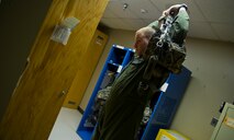 Staff Sgt. Jake Gornbein, 54th Helicopter Squadron special missions aviator instructor, puts his gear on at Minot Air Force Base, N.D., May 13, 2014. SMAs mission at Minot AFB is 24/7 Nuclear Security for not only the 791st Missile Security Forces Squadron convoys section but the missile field as well. (U.S. Air Force photo/Senior Airman Brittany Y. Bateman)