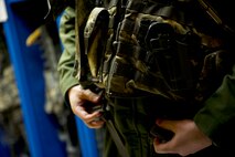 Staff Sgt. Jake Gornbein, 54th Helicopter Squadron special missions aviator instructor, puts his gear on at Minot Air Force Base, N.D., May 13, 2014. SMAs mission at Minot AFB is 24/7 Nuclear Security for not only the 791st Missile Security Forces Squadron convoys section but the missile field as well. (U.S. Air Force photo/Senior Airman Brittany Y. Bateman)