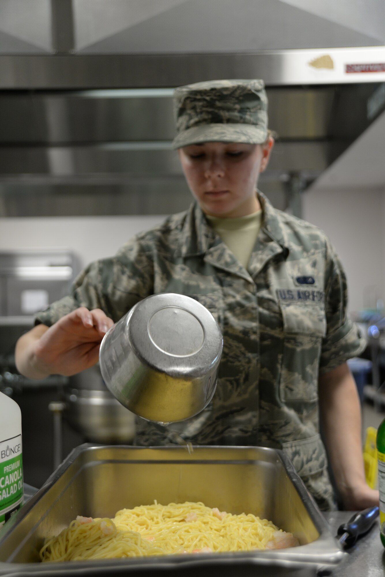 U.S. Air Force Airman Eran Menard, 20th Force Support Squadron food service specialist, prepares a tray of shrimp spaghetti at the Chief Master Sgt. Emerson E. William Dining Facility, May 21, 2014, Shaw Air Force Base, S.C. The Airmen have to adhere to strict recipes when preparing food, otherwise they could potentially lose money. (U.S. Air Force photo by Airman 1st Class Michael A. Cossaboom/Released) 