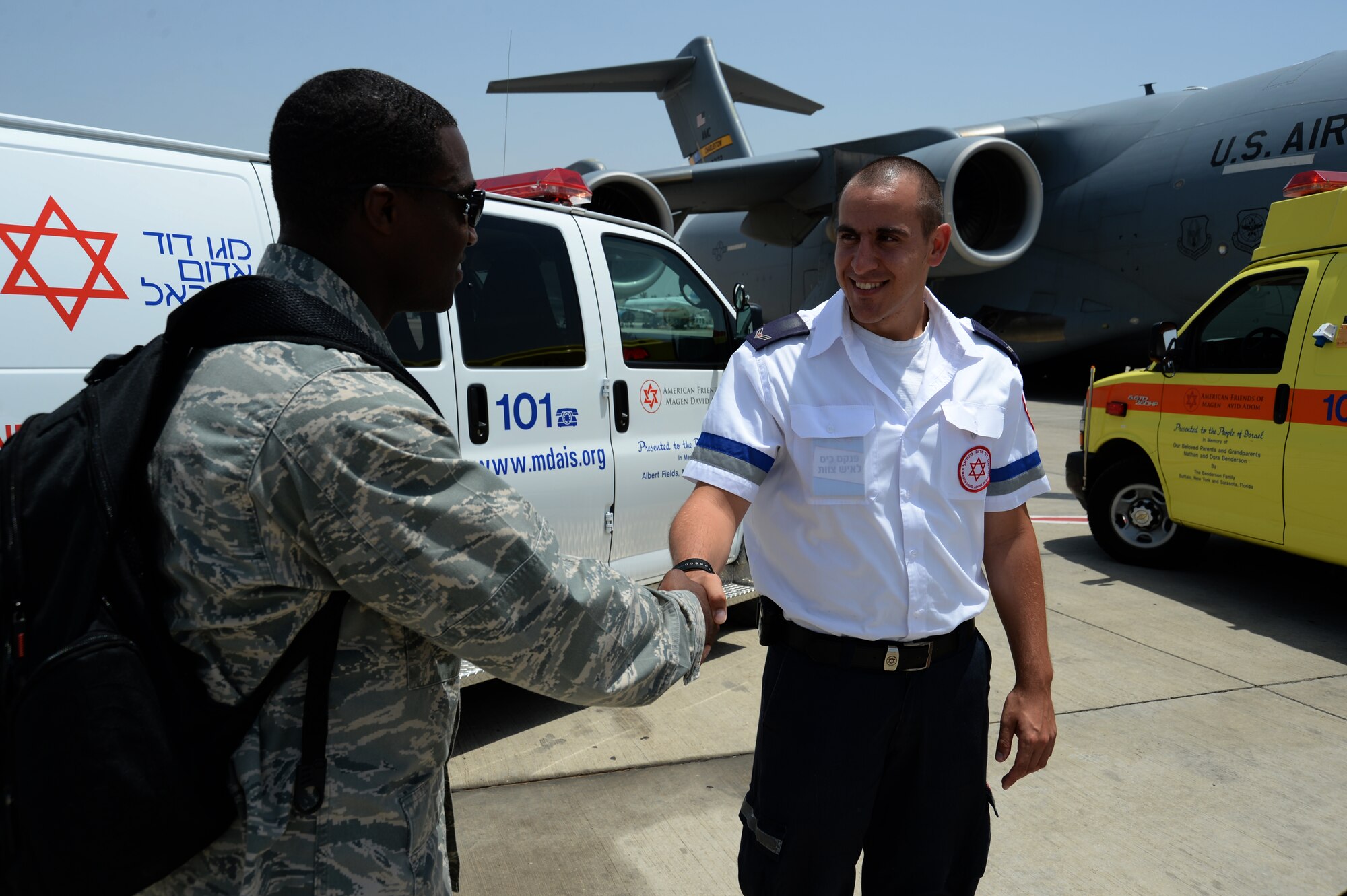U.S. Air Force Capt. Jason Carter, medical readiness flight commander assigned to the 86th Medical Support Squadron at Ramstein Air Base, Germany, and Rockford, Ill., native, left, shakes the hand of Amit Michael, a Magen David Adom special medic, right, in front of a U.S. Air Force C-17 Globemaster cargo aircraft and two Israeli ambulances after a simulated medical evacuation on the flightline of Ben Gurion International Airport in Tel Aviv, Israel, May 20, 2014 as part of the Juniper Cobra 14 defense training exercise. JC14 is part of a long-standing agreement between U.S. European command and the Israeli Defense Force to hold bilateral training exercises on a regular basis in order to promote and sustain regional stability, and to ensure Israel’s qualitative military edge. (U.S. Air Force photo by Staff Sgt. Joe W. McFadden/Released)