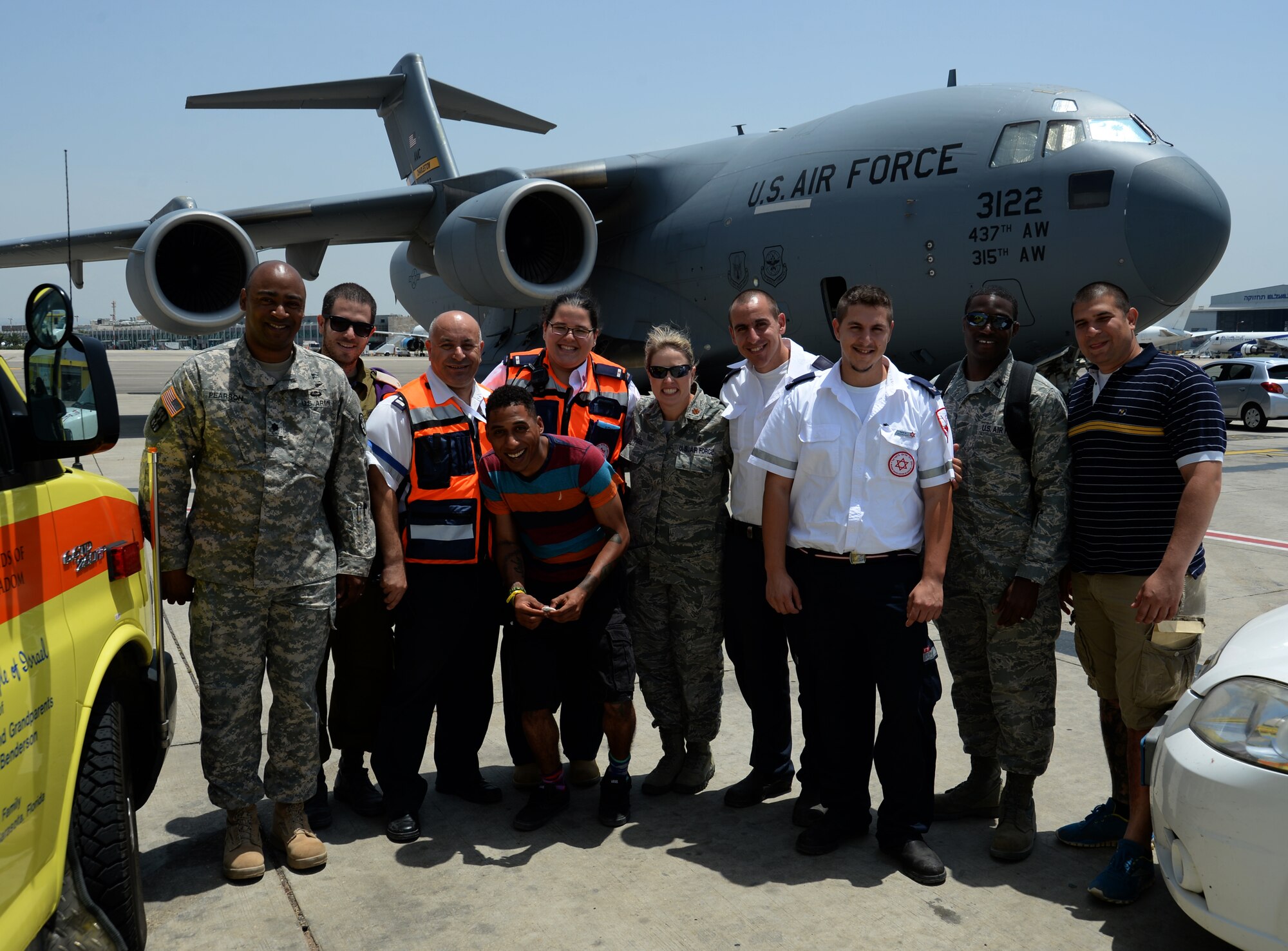 U.S. service members and Israeli medics pose for a photo in front of a U.S. Air Force C-17 Globemaster cargo aircraft and two Israeli ambulances after a simulated medical evacuation on the flightline of Ben Gurion International Airport in Tel Aviv, Israel, May 20, 2014 as part of the Juniper Cobra 14 defense training exercise. The medical exercise tested both nations' ability to communicate and track transportation of a simulated patient from the scene of an injury to a hospital and to a U.S. military aircraft. (U.S. Air Force photo by Staff Sgt. Joe W. McFadden/Released)