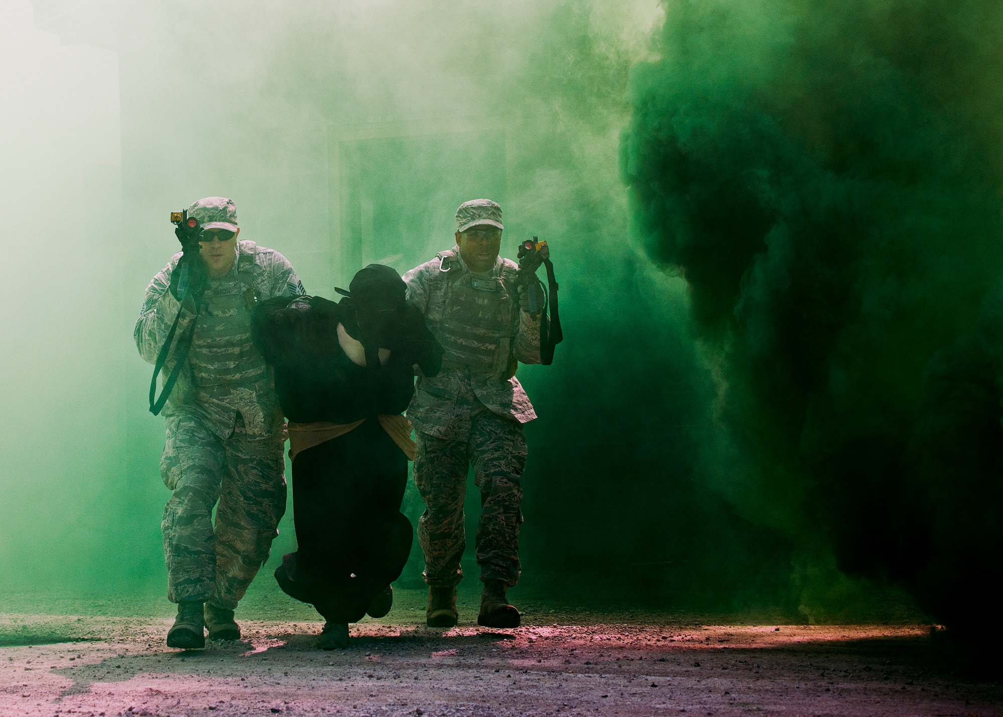 Staff Sgt.s Matthew Krause and Sterling Wynn, of the 96th Ground Combat Training Squadron, move through the cover of smoke during a high value target capture demonstration at Eglin Air Force Base, Fla.  The squadron is responsible for “Brave Defender” deployment training for approximately 1,500 Air Force security forces Airmen per year.  The squadron is scheduled for deactivation this summer.  (U.S. Air Force photo/Samuel King Jr.)