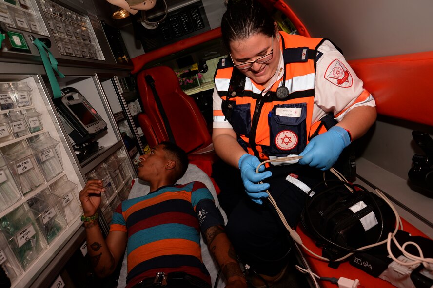 Marine Attias, a Magen David Adom paramedic, puts away medical equipment as U.S. Army Private 1st Class James Black, a multi-channel radio operator maintainer assigned to the 44th Signal Battalion at Grafenwoehr, Germany, and Atlanta native, reviews his heart rate on a monitor while onboard an ambulance during a simulated medical evacuation as part of the Juniper Cobra 14 defense training exercise in Israel, May 20, 2014. The goal of JC14 is to exercise both nations’ active defense forces and to improve their combined ability to defend against missile attacks. (U.S. Air Force photo by Staff Sgt. Joe W. McFadden/Released)