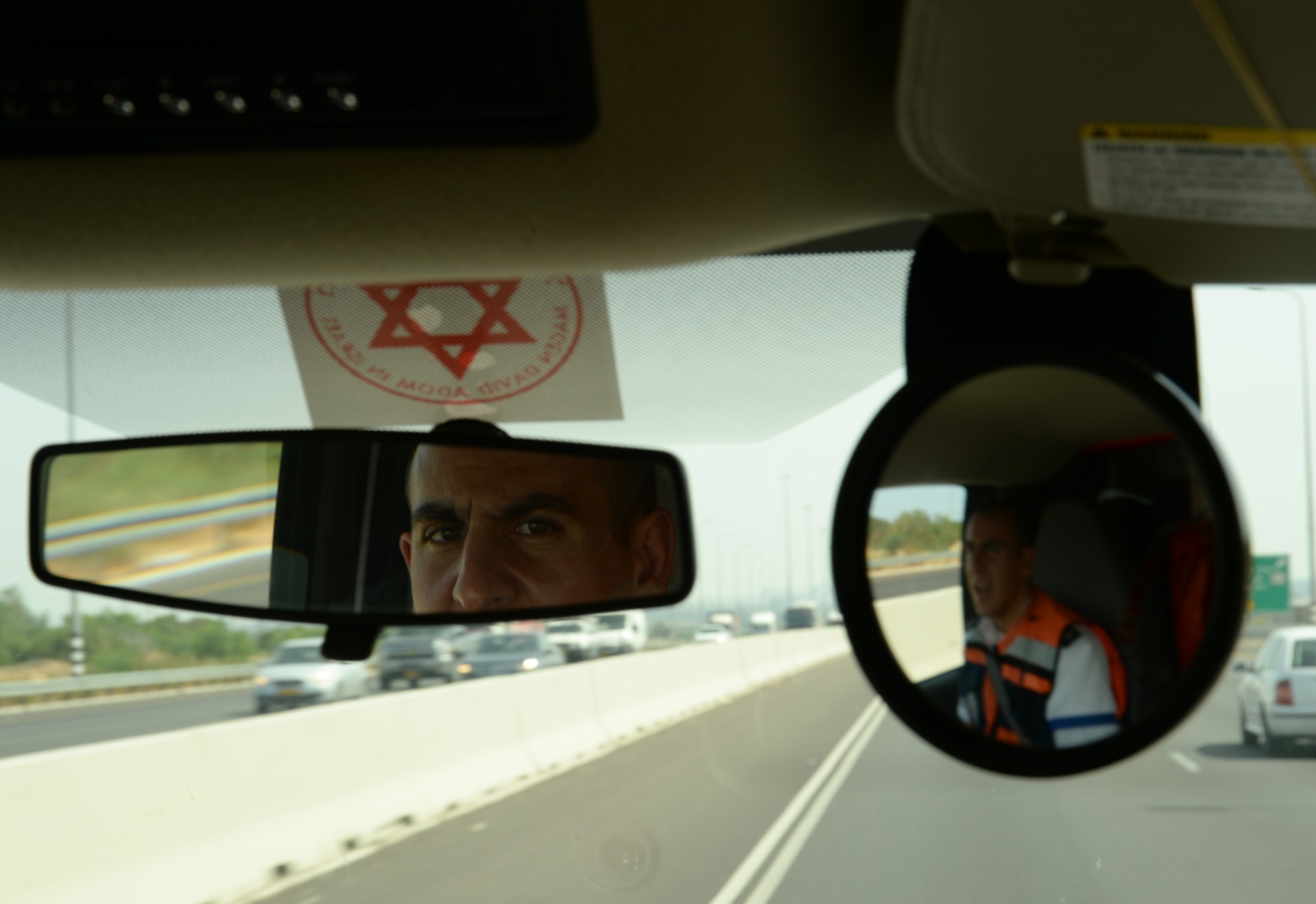 Amit Michael, a Magen David Adom special medic, glances in the rearview mirror of his ambulance during a simulated medical evacuation as part of the Juniper Cobra 14 defense training exercise in Israel, May 20, 2014. JC14 will have minimal environmental impact as U.S. and Israeli forces participating in JC14 have been instructed to take all measures to protect the environment. (U.S. Air Force photo by Staff Sgt. Joe W. McFadden/Released)