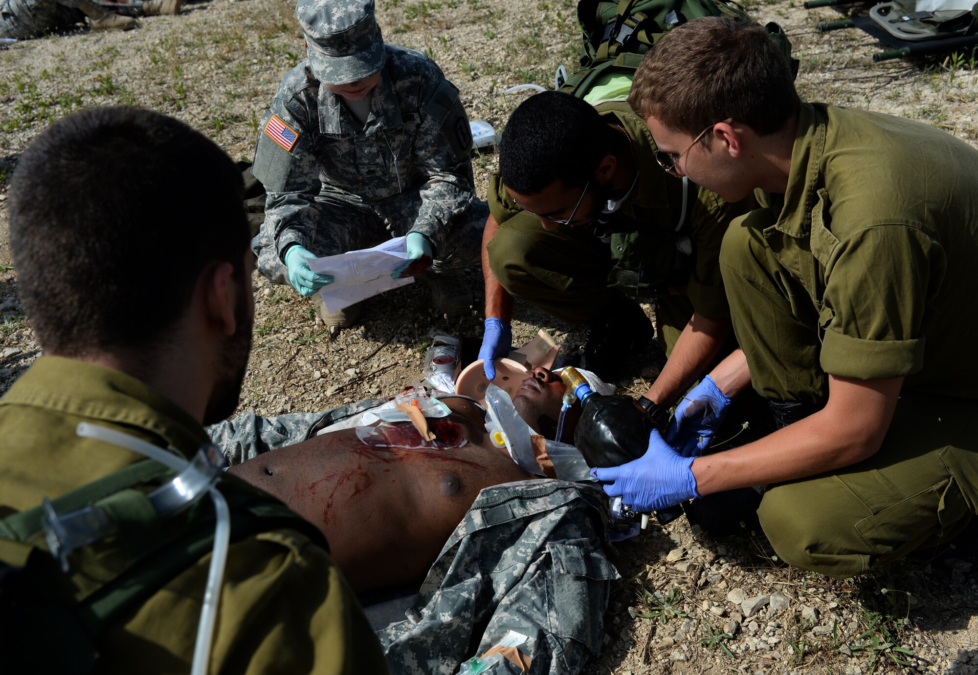 Israeli and U.S. military medics treat the simulated wounds on U.S. Army Staff Sgt. Willie Morgan, a generator mechanic assigned to the 10th Army and Missile Defense Command at Kaiserslautern, Germany, and Atlanta native, during a simulated medical evacuation as part of the Juniper Cobra 14 defense training exercise at Hatzor Air Base, Israel, May 20, 2014. Approximately 2,000 U.S. service members and civilians stationed in Europe and the United States traveled to Israel to participate in JC14 as a training audience or exercise evaluators.  (U.S. Air Force photo by Staff Sgt. Joe W. McFadden/Released)