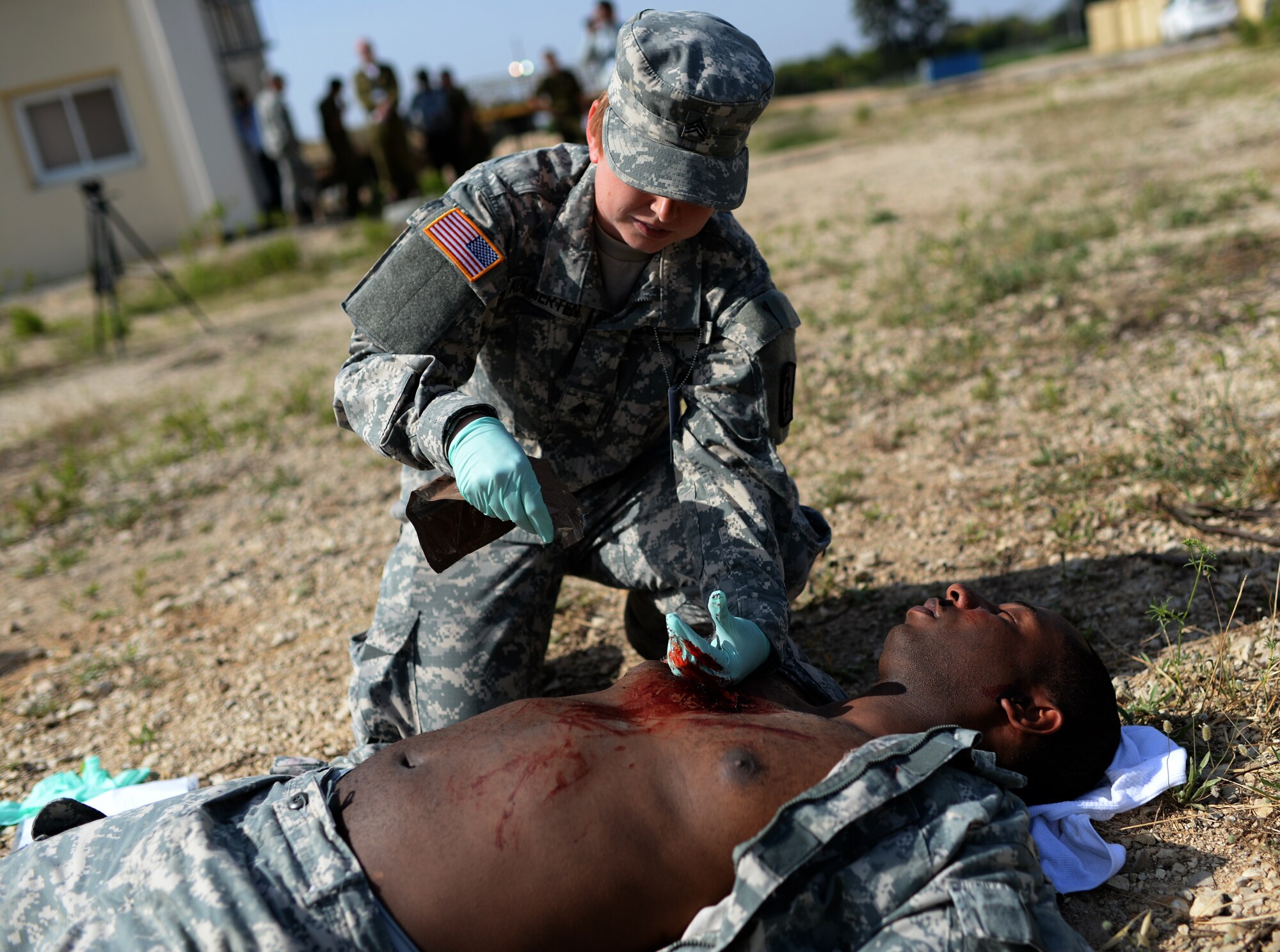 U.S. Army Sgt. Tiffany Kolmerten, a medic assigned to the 557th Medical Company and Fort Wayne, Ind., native, simulates treating Staff Sgt. Willie Morgan, a generator mechanic assigned to the 10th Army and Missile Defense Command at Kaiserslautern, Germany, and Atlanta native, during a simulated medical evacuation as part of the Juniper Cobra 14 defense training exercise at Hatzor Air Base, Israel, May 20, 2014. JC14 is driven by the regional dynamics of the Middle East but is not related to any specific current incident or development.  (U.S. Air Force photo by Staff Sgt. Joe W. McFadden/Released)