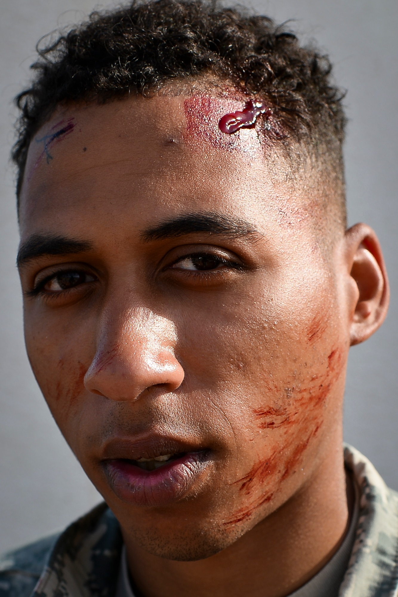 U.S. Army Private 1st Class James Black, a multi-channel radio operator maintainer assigned to the 44th Signal Battalion at Grafenwoehr, Germany, and Atlanta native, poses after having medical makeup applied to his face during a simulated medical evacuation as part of the Juniper Cobra 14 defense training exercise at Hatzor Air Base, Israel, May 20, 2014. JC14 exercises both countries’ interoperability while maintaining and improving Israel’s defensive capacity. (U.S. Air Force photo by Staff Sgt. Joe W. McFadden/Released)