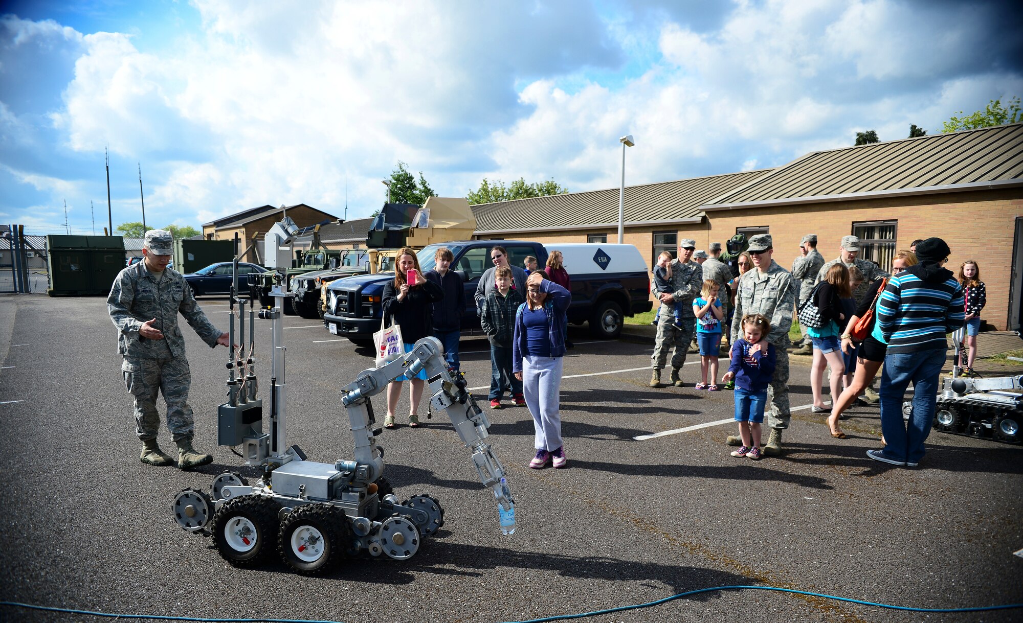 Airman 1st Class Paul Christiansen, 48th Civil Engineer Squadron explosive ordnance disposal technician, left, explains the capabilities of an Air Force medium-sized robot to a group of students and parents during Job Shadow Day at Royal Air Force Lakenheath, England, May 23, 2014. Job Shadow Day provided children the opportunity to see and learn about different Air Force jobs and allowed hands-on experience in an interactive environment. (U.S. Air Force photo by Staff Sgt. Emerson Nuñez/Released)