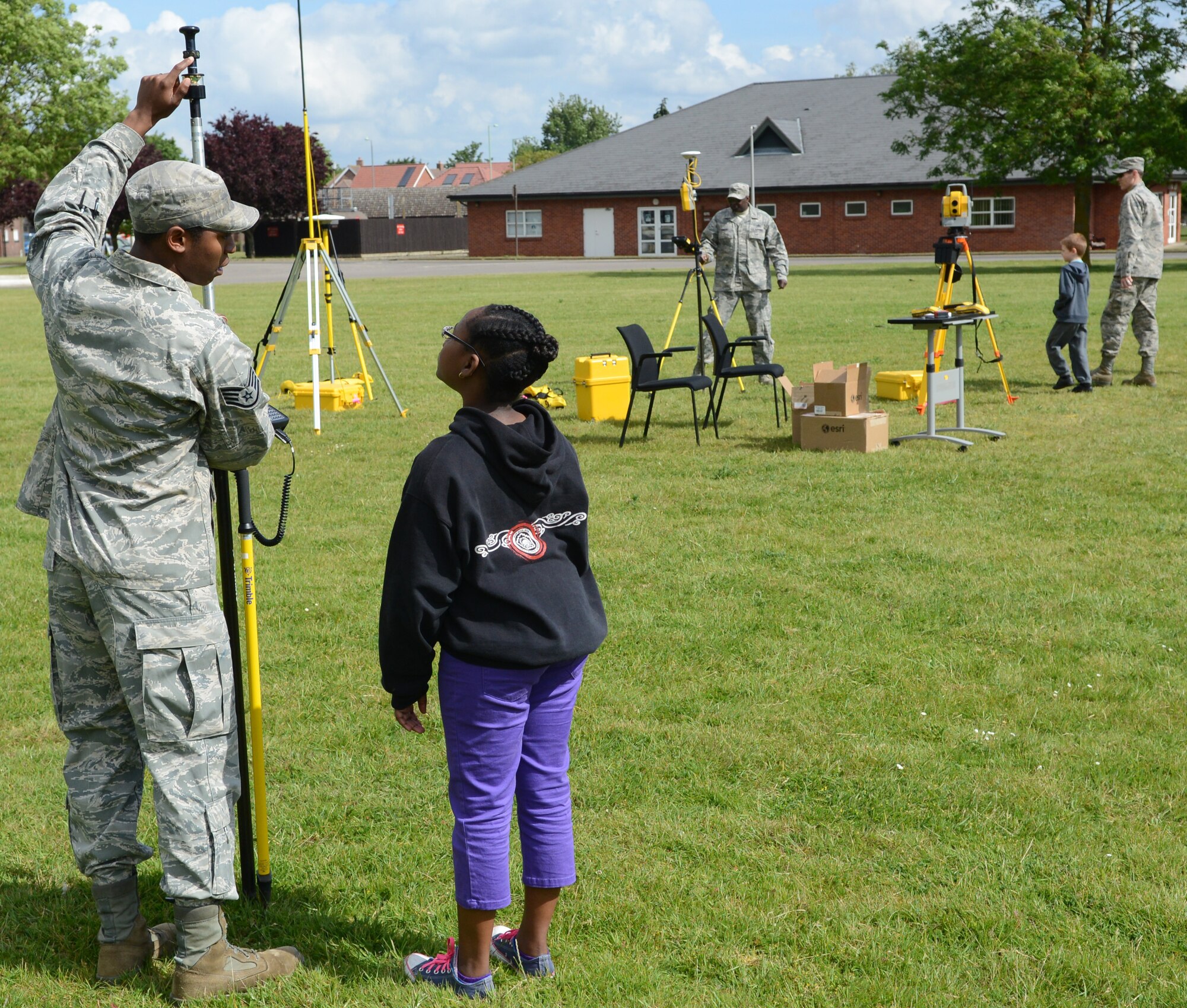 U.S. Air Force Staff Sgt. Erik Holloman, left, 100th Civil Engineer Squadron NCO in charge of Geobase from Washington, D.C., demonstrates the use of Geobase equipment to Jourdyn Brewster, daughter of U.S. Air Force Master Sgt. Dave Brewster, 100th CES superintendent of service contracts from Brooklyn, N.Y., May 23, 2014, during the Team Mildenhall job shadow day on RAF Mildenhall, England. Children were given the opportunity to see what happens on base in RAF Mildenhall’s squadrons. (U.S. Air Force photo by Airman 1st Class Dillon Johnston/Released)