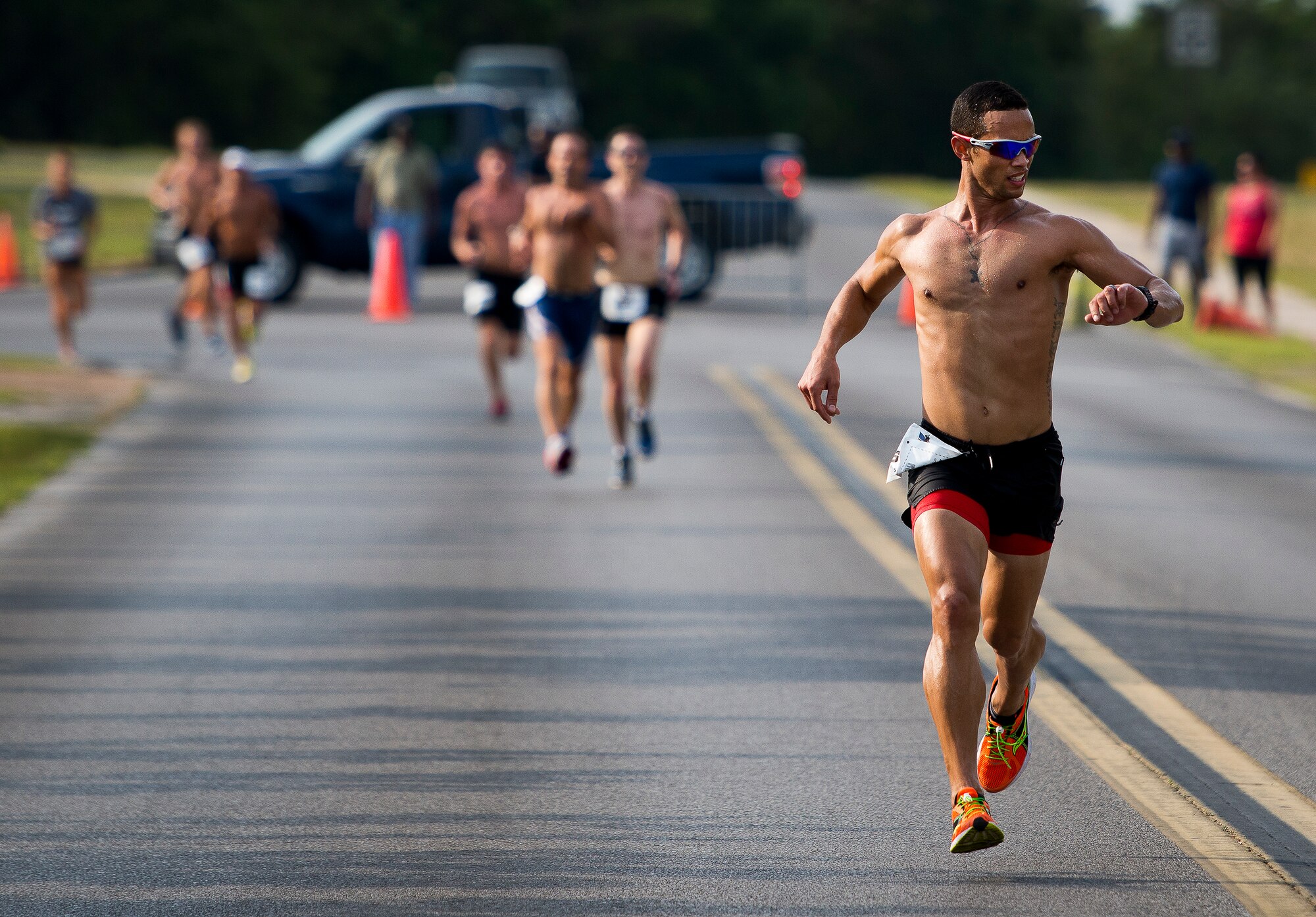 A runner checks his time as he strides toward the finish line at the 29th annual Gate-to-Gate Run May 24 at Eglin Air Force Base, Fla. More than 1,200 people participated in the 4.4-mile race. Many of the runners paid their respects by dropping off flowers in front of the All Veterans Memorial as they raced by. (U.S. Air Force photo/Samuel King Jr.)