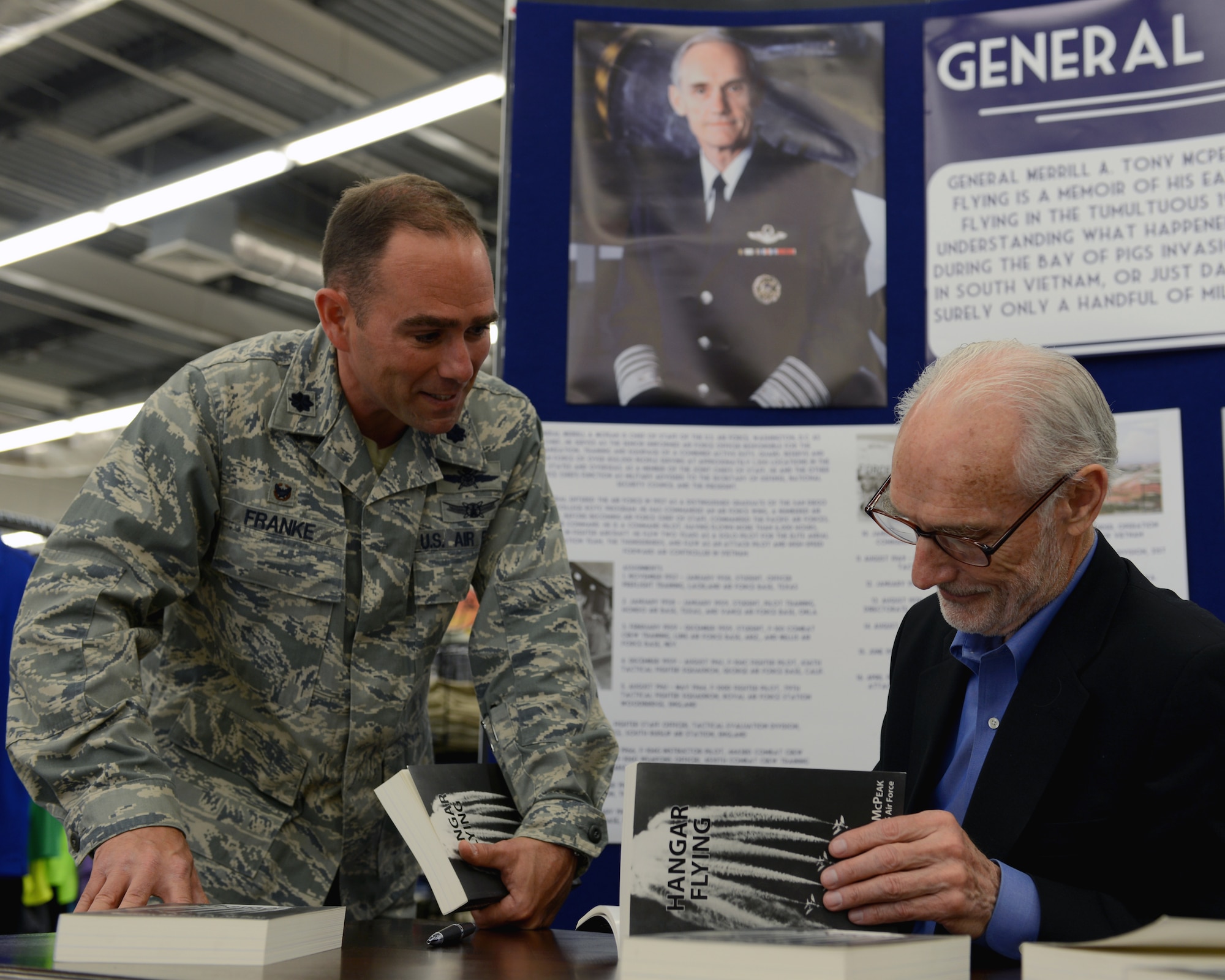 U.S. Air Force Lt. Col. Albert Franke, 100th Communication Squadron commander, speaks with retired U.S. Air Force Gen. Merrill A. McPeak, the 14th chief of staff of the Air Force, during a book signing event May 24, 2014 at the BXtra on RAF Mildenhall, England. McPeak signed copies of his book, Hangar Flying, during his visit to the base. (U.S. Air Force photo by Airman 1st Class Preston Webb/Released)