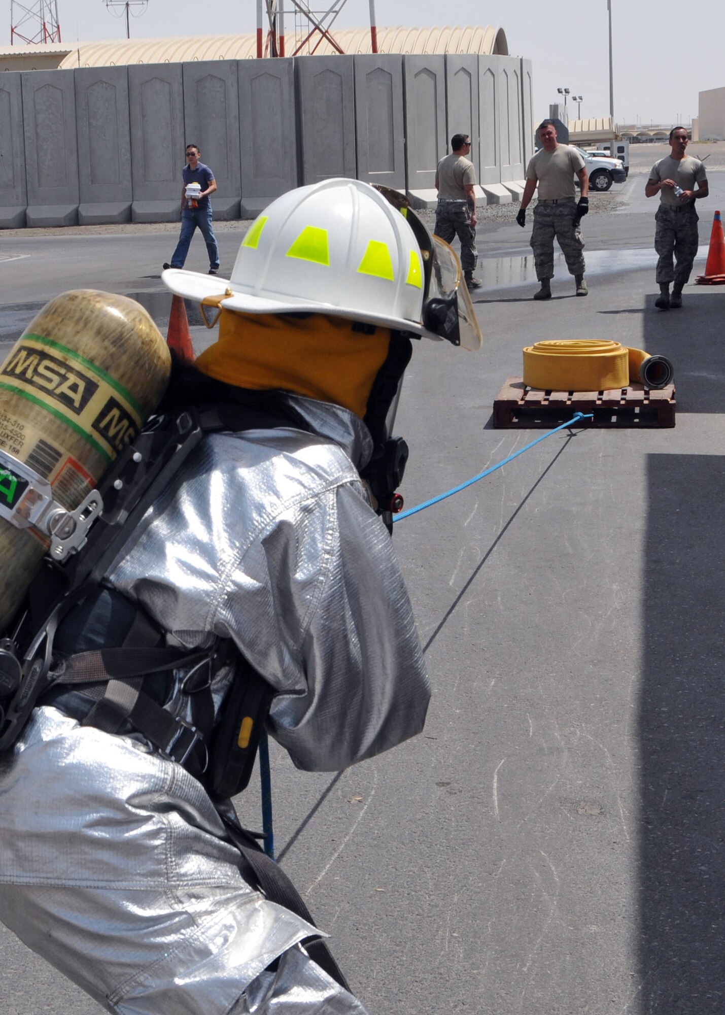 Air Force Capt. Maggie Coppini, a member of the 380th Air Expeditionary Medical Group’s preventative medicine flight, pulls a pallet of firefighting equipment during the firefighter challenge obstacle course conducted by the fire department at fire station one in an undisclosed location on May 21, 2014. (U.S. Air Force photo by Senior Master Sgt. Eric Peterson/Released)