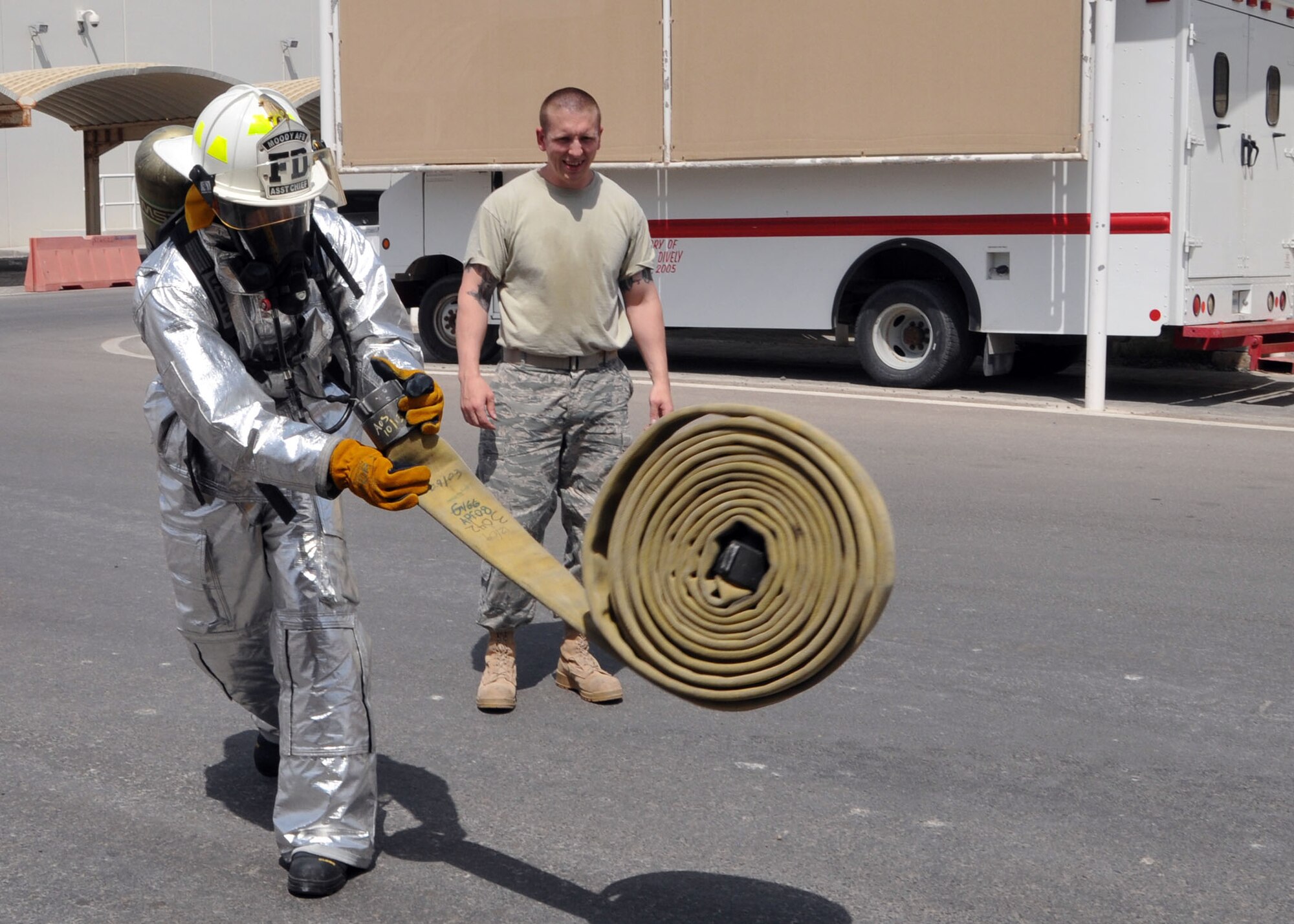 Air Force Staff Sgt. John Thorpe, a member of the 380th Air Expeditionary Medical Group’s preventative medicine flight, unrolls a fire hose during the firefighter challenge obstacle course conducted by the fire department at fire station one in an undisclosed location on May 21, 2014. (U.S. Air Force photo by Senior Master Sgt. Eric Peterson/Released)