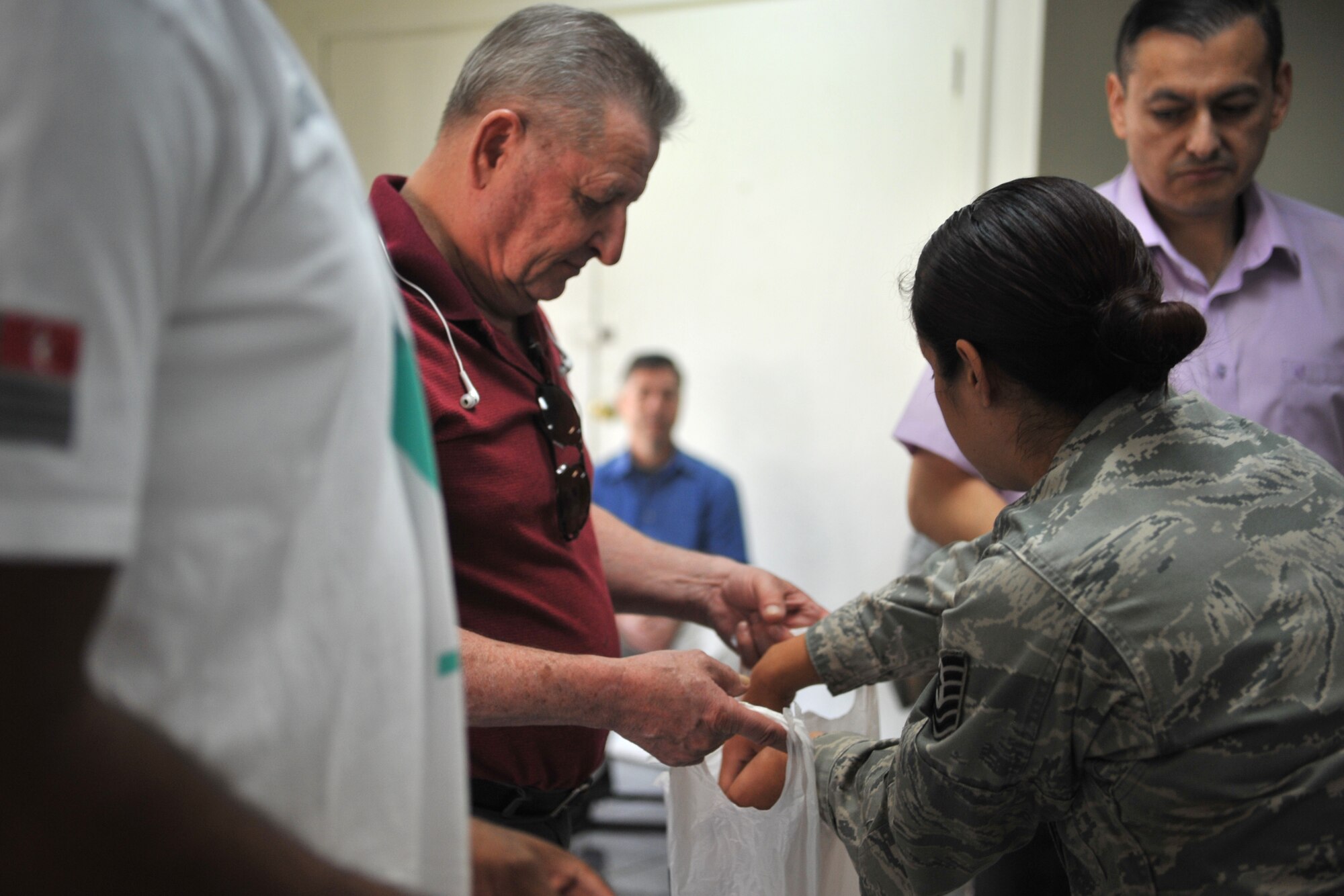 Tech. Sgt. Alejandra Chavez, 51st Fighter Wing Equal Opportunity Office NCO in charge and sexual assault prevention and response training facilitator, places rolled up paper into a bag held by John Okonski, 51st FW historian, during a training scenario during SAPR Down Day at Osan Air Base, Republic of Korea, May 22, 2014. Each member of the base was required to attend a commander’s call before individual units split up to conduct small group training. (U.S. Air Force photo/Airman 1st Class Ashley J. Thum)