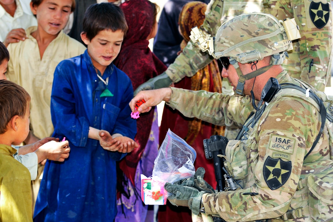 U.S. Army Command Sgt. Major Joseph Dallas, right, gives toys to Afghan children during Operation Southern Fist in Obezhan Kalay village in the Spin Boldak district in Afghanistan's Kandahar province, Sept. 30, 2012. Dallas, a senior enlisted advisor, is assigned to the 2nd Infantry Division's 5th Battalion, 20th Infantry Regiment, 3rd Stryker Brigade Combat Team.  
