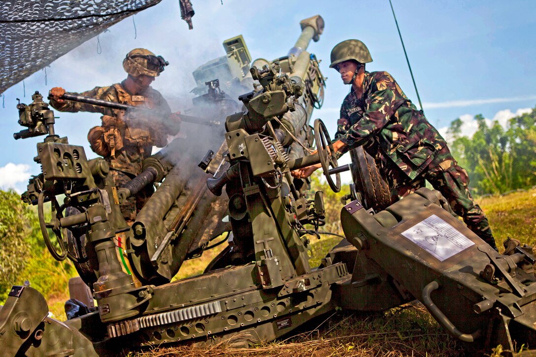 U.S. Marine Corps Lance Cpl. Alec Wines, left, and Philippine army Pfc. Jaymancio Pablo clean an M777 howitzer after it was fired during Amphibious Landing Exercise 2013 on Fort Magsaysay in Palayan City, Neuva Ecija, Philippines, Oct. 10, 2012. Wines is assigned to 2nd Battalion, 1st Marine Regiment, 31st Marine Expeditionary Unit. 
