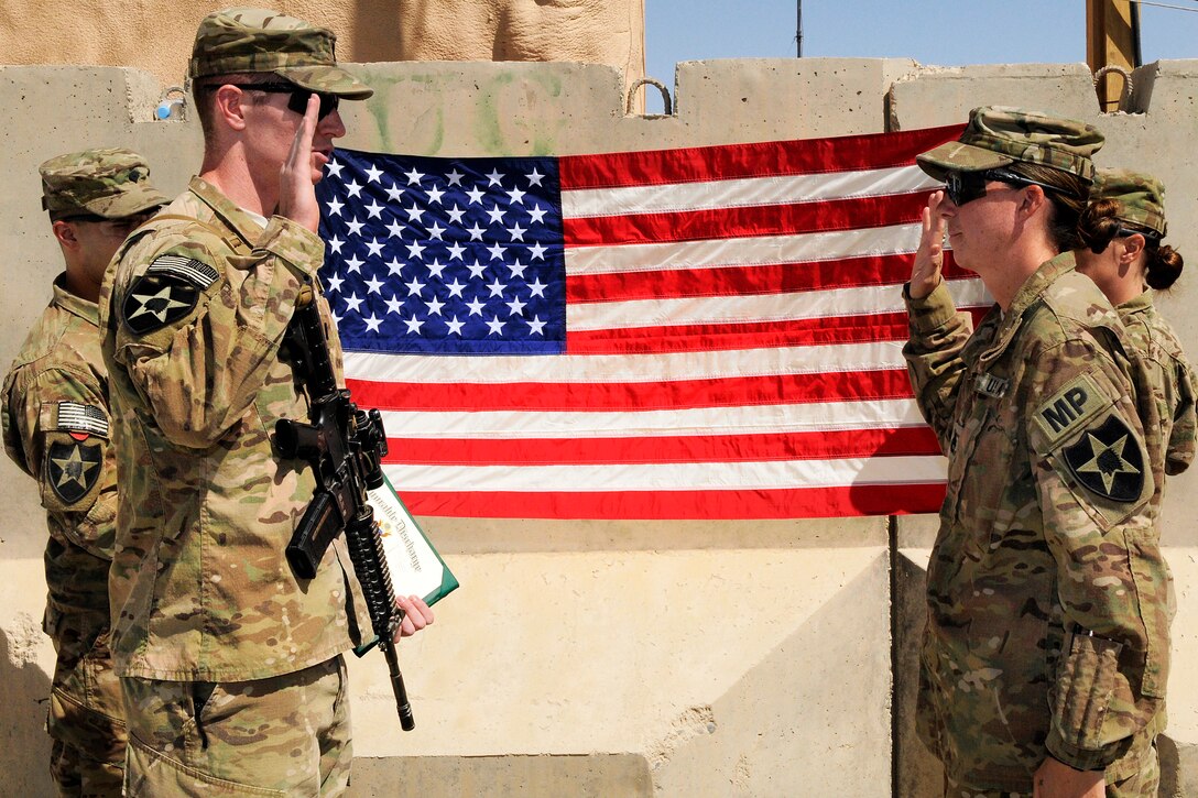 U.S. Army Staff Sgt. Rebecca Osborn, right, re-enlists during a ceremony on Forward Operating Base Spin Boldak, Afghanistan, Oct. 7, 2012. Osborn, a military police officer, is assigned to the 2nd Infantry Division's 5th Battalion, 20th Infantry Regiment, 3rd Stryker Brigade Combat Team.  
