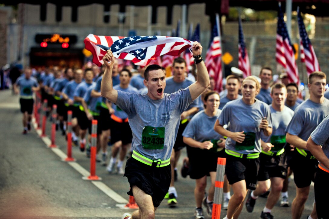 A soldier sprints while carrying an American flag during the New York City Tunnel to Towers Run to raise awareness for military causes in New York, Sept. 30, 2012. U.S. Military Academy at West Point cadets and New York firefighters lined the final stretch of the run. The event supports the Stephen Siller Tunnel to Towers Foundation, which works to build homes for injured troops and provide scholarships for the children of fallen service members and firefighters.  
