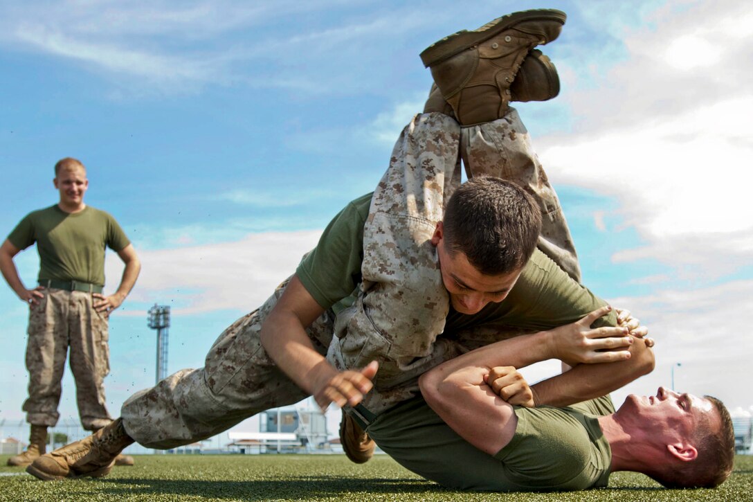 U.S. Marine Corps Lance Cpl. Ruben Clark and Lance Cpl. Andrew Stagmer wrestle on the football field in Yokosuka, Japan, Sept. 10, 2012. The Marines are learning different combat techniques as part of the Marine Corps Martial Arts Program. Clark and Stagmer are assigned to the Marine Corps Security Company Pacific Fleet Antiterrorism Security Team Bravo.  
