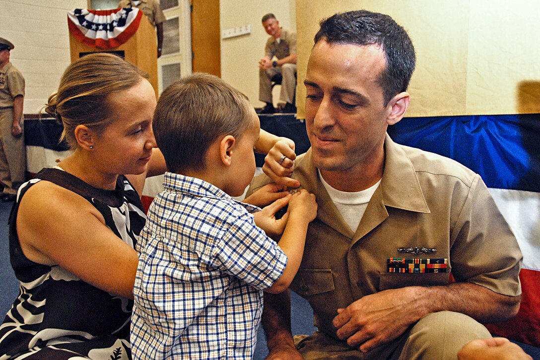 Newly frocked Navy Chief Petty Officer Manuel Soares receives his collar devices from his son and wife during a pinning ceremony at Naval Station Norfolk, Va., Sept. 14, 2012. Soares is a machinist's mate. 

