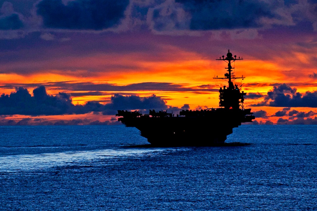 The aircraft carrier USS George Washington sails through calm seas near Guam at sunset while under way in the Pacific Ocean, Sept. 8, 2012. The George Washington is the centerpiece of Carrier Strike Group 5, the US Navy’s only continuously forward deployed carrier strike group, based out of Yokosuka, Japan. Carrier Strike Group 5 is currently on a routine Western Pacific patrol.  
