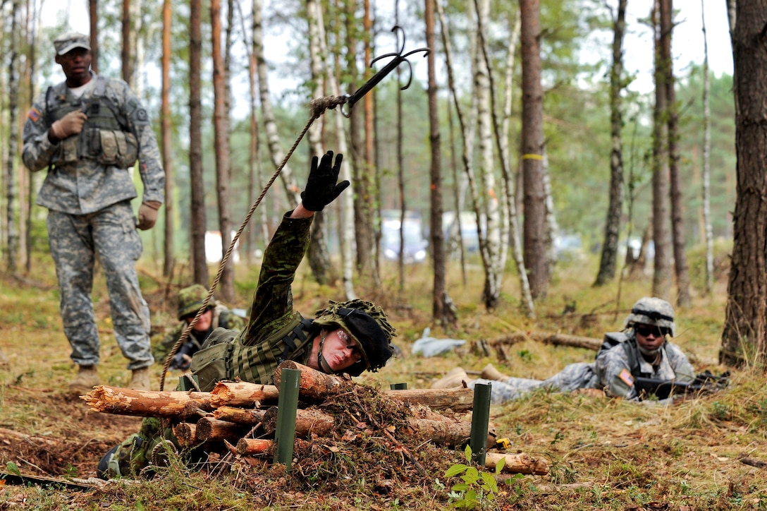 An Estonian soldier throws a grappling hook at a testing lane during the U.S. Army Europe's Expert Field Medical Badge competition in Grafenwoehr, Germany, Sept. 13, 2012.  
