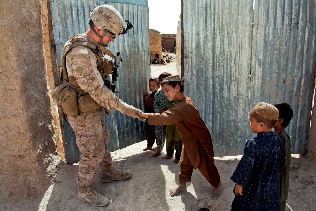 U.S. Marine Corps Cpl. Patrick McCall, left, receives a high five from an Afghan boy during a security patrol in the Sangin district of Afghanistan's Helmand province, Sept. 6, 2012. McCall is a rifleman assigned to Bravo Company, 1st Battalion, 7th Marine Regiment, Regimental Combat Team 6.  
