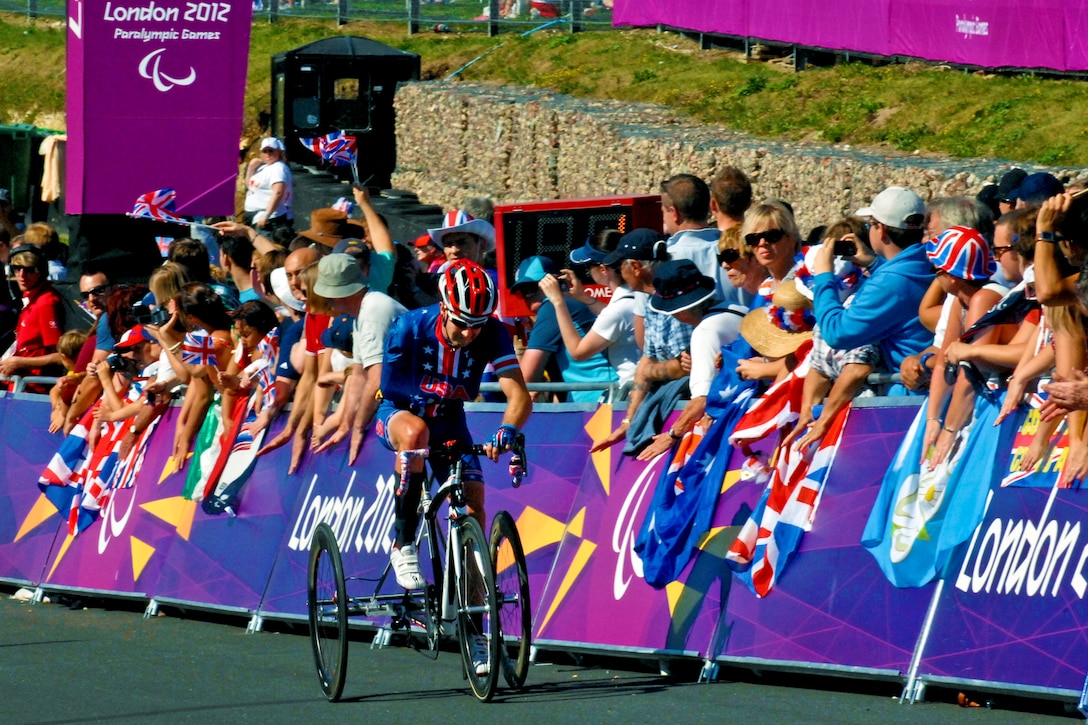 Steven Peace, a U.S. Navy veteran and U.S. Paralympic road cyclist, rides past fans while negotiating a hill as he completes the first of three laps for the 24-kilometer road race during the 2012 Paralympic Games in London, Sept. 8, 2012.  
