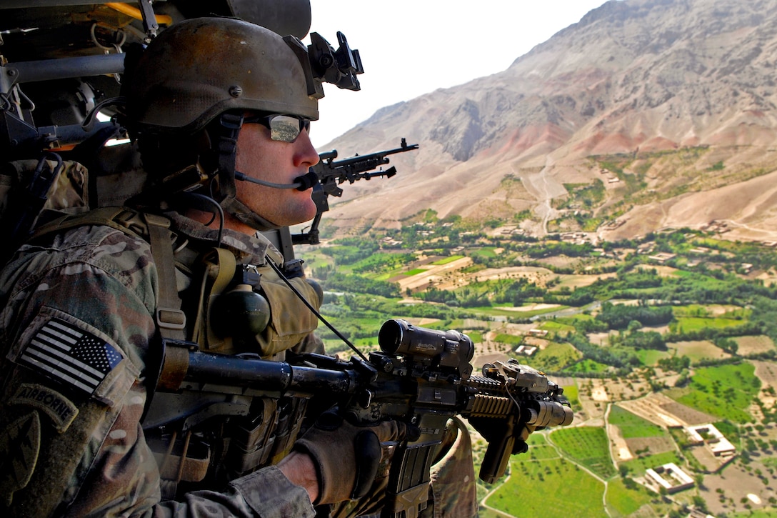 A coalition special operations forces member looks out over Khas Uruzgan from the open door of a UH-60 Black Hawk helicopter in Afghanistan's Uruzgan province, Aug. 29, 2012.  
