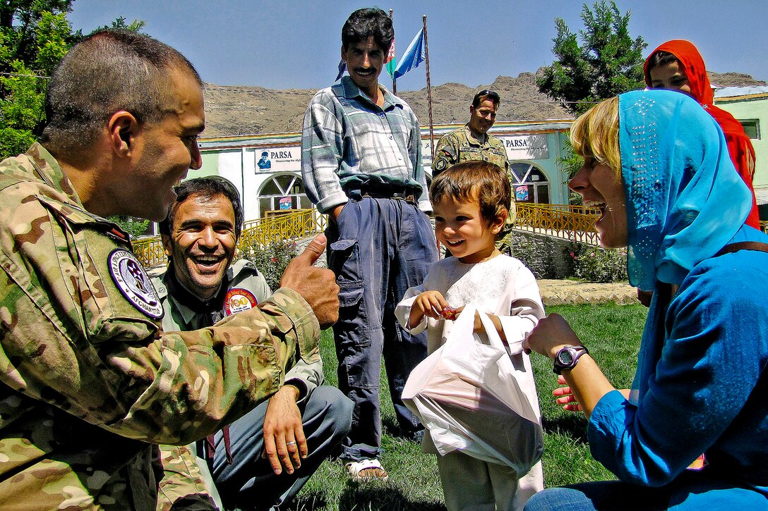 International Security Assistance Force members play with an Afghan child at the Physiotherapy and Rehabilitation Support for Afghanistan Orphanage in Kabul, Afghanistan, Aug. 31, 2012. The service members were on hand to pass out school supplies and candy to children at the orphanage.  
