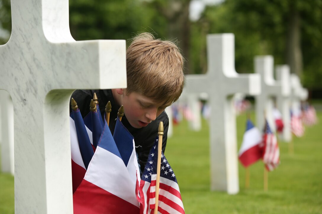 Volunteers including Marines, familly members and grounds keepers placed French and American flags in front each of the 2,289 grave markers on Saturday prior to the Belleau Wood memorial. United States Marines and their French counterparts gathered at Aisne-Marne American Cemetery May 25 to celebrate Memorial Day, and to mark the 96th anniversary of the historic Battle of Belleau Wood. The event was held in the memorial cemetery which lies adjacent to the historic grounds of Belleau Wood and featured the laying of wreathes, a firing of volleys, the playing of "TAPS," raising of the American and French national colors, and a concert by the French and Marine Corps military bands. The mayor of the village of Bellau along with other military officers and officials representing the U.S. and France were present along with hundreds of locals and visitors from around the world. Participating units from the U.S. Marines included 5th Marine Regiment, the Wounded Warrior Regiment and Marine Forces Europe and Africa. French units that participated in the ceremony included the 21st Marine Infantry Regiment and the Musique Principale des Troupes de Marines.

