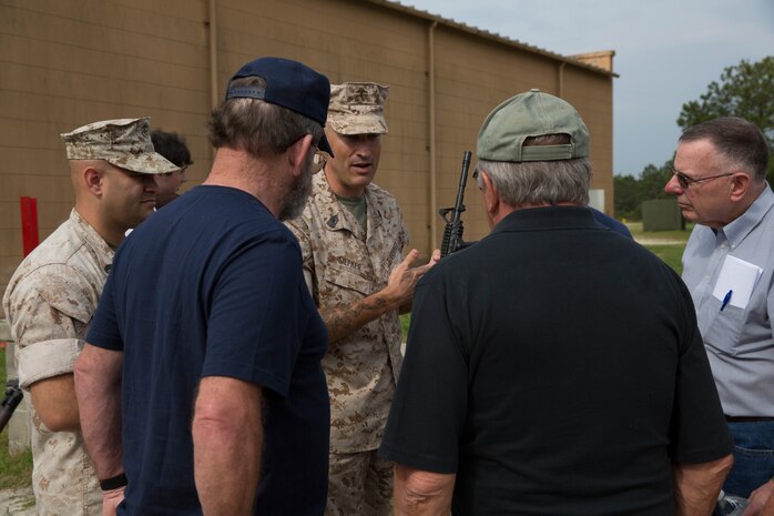 Master Gunnery Sgt. Geoffrey Siepker (center), a field artillery operations man with Headquarters and Support Battalion, Marine Corps Base Camp Lejeune, describes the changes in weapons technology since the Vietnam War to veterans of Mobile Construction Battalion 12 at the Military Operations in Urban Terrain facility during a reunion aboard Camp Lejeune, N.C., May 22, 2014. The retired Seabees from MCB-12 held a reunion on Camp Lejeune, where they trained for two weeks prior to a deployment to Vietnam in 1968.