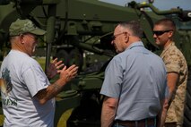 A veteran of Mobile Construction Battalion 12 speaks with Lance Cpl. Craig Murphy Jr. (right), an engineer equipment operator with 8th Engineer Support Battalion, 2nd Marine Logistics Group, at a static display of engineer and support equipment and vehicles during a reunion aboard Camp Lejeune, N.C., May 22, 2014. The display gave the veterans and their family members an idea of how support equipment and vehicles have changed throughout the past 50 years and an opportunity to share their stories with a newer generation of service members.