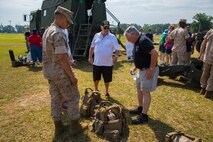 A Marine with 10th Marine Regiment, 2nd Marine Division and veterans of Mobile Construction Battalion 12 discuss the differences in body armor used in the Vietnam War and current models during a reunion at Camp Lejeune, N.C., May 22, 2014. Displays of current equipment provided the veterans with an opportunity to see the changes in engineering and support capabilities as well as a chance to share their past experiences with a younger generation of service members.
