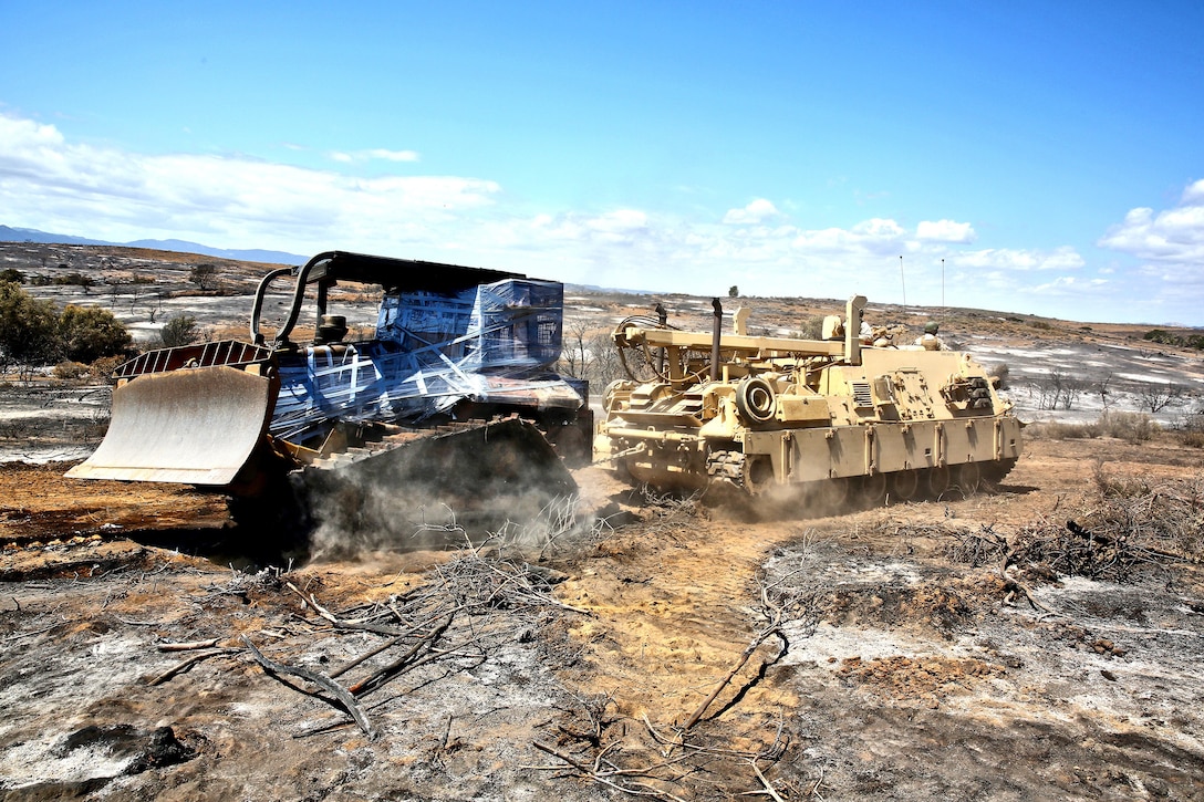 Marines with Maintenance Detachment, Combat Logistics Battalion 15, Headquarters Regiment, 1st Marine Logistics Group, tow a downed bulldozer with an M88 Recovery Vehicle aboard Naval Weapons Station Seal Beach Detachment Fallbrook, Calif., May 21, 2014. The bulldozer, owned and operated by the National Forest Service, was used to create firebreaks and help contain the wildfires that spread across Southern California beginning May 14. Sergeant Ryan M. Stites, an amphibious assault vehicle mechanic, and his team of Marines, volunteered to recover the bulldozer for the Forest Service using their M88 Recovery Vehicle. Stites, 26, is from Arcanum, Oh. 